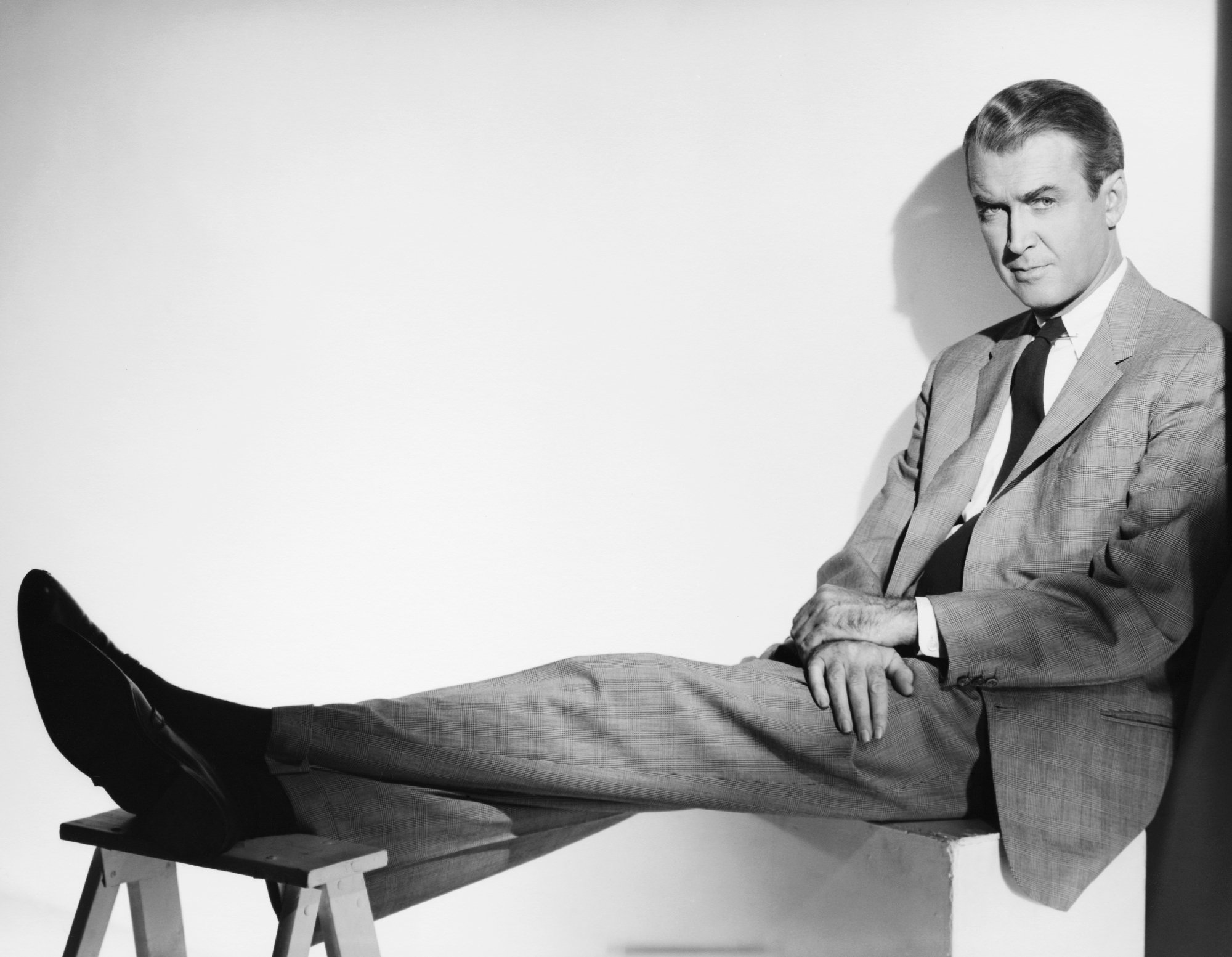 Jimmy Stewart, who spoke his last words about his late wife. He's wearing a suit and tie and resting his feet on a stool