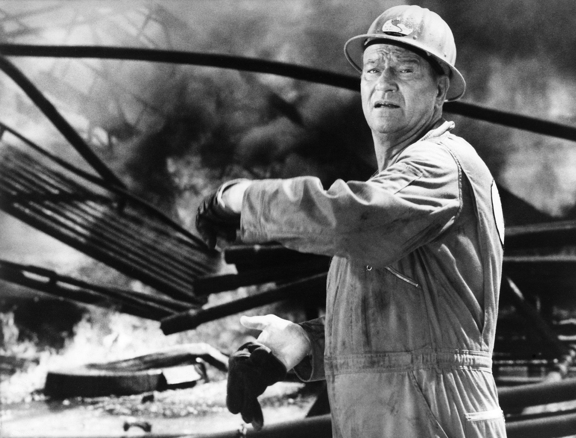 John Wayne, who raged at negative movie critics' reviews. He's wearing a hard hat and waving his hand.