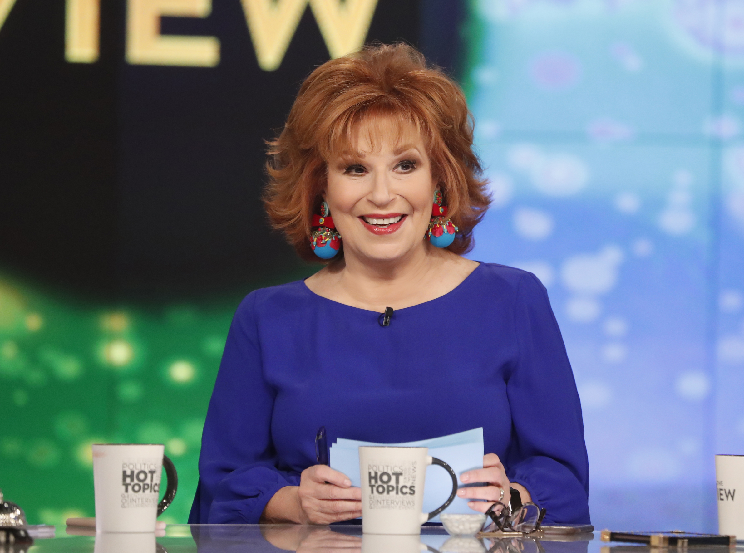 Joy Behar, who's net worth is an estimated $30 million, sits at 'The View' holding note cards.