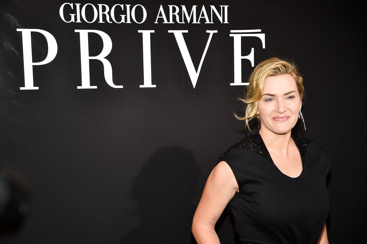 Kate Winslet posing while wearing a black dress.