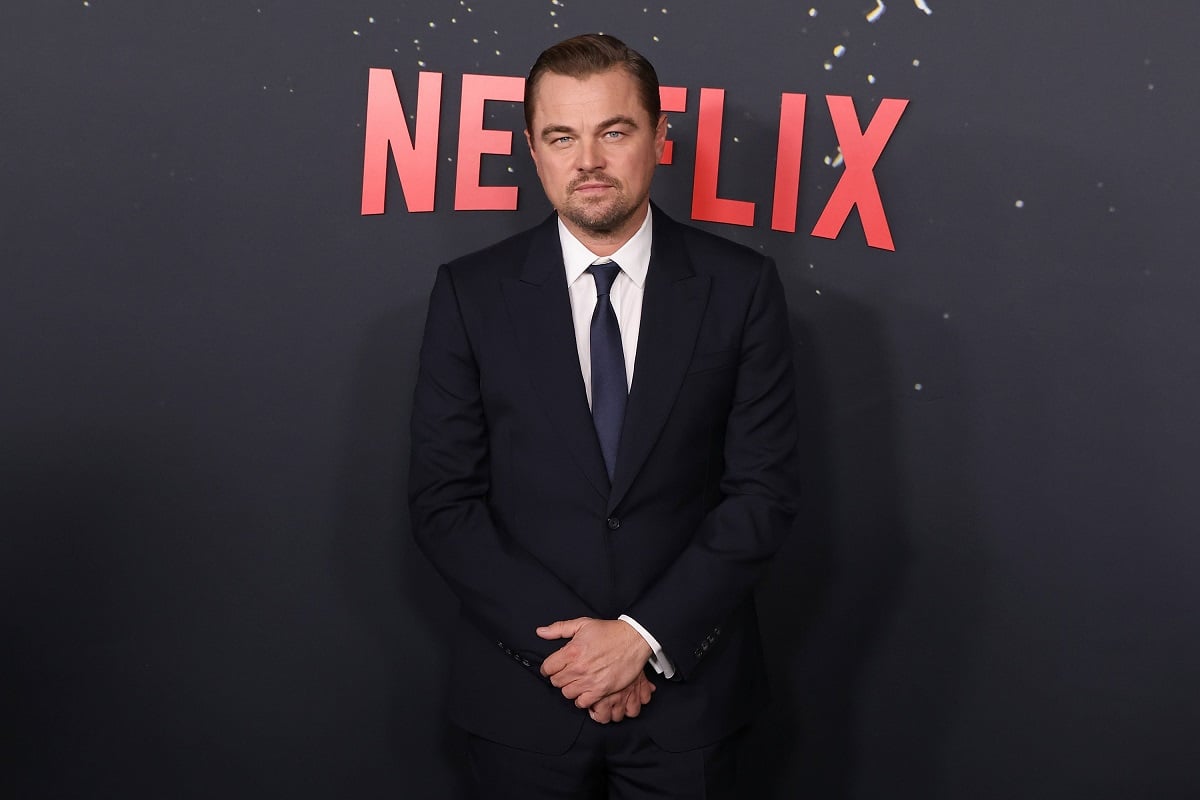 Leonardo DiCaprio posing while wearing a suit.