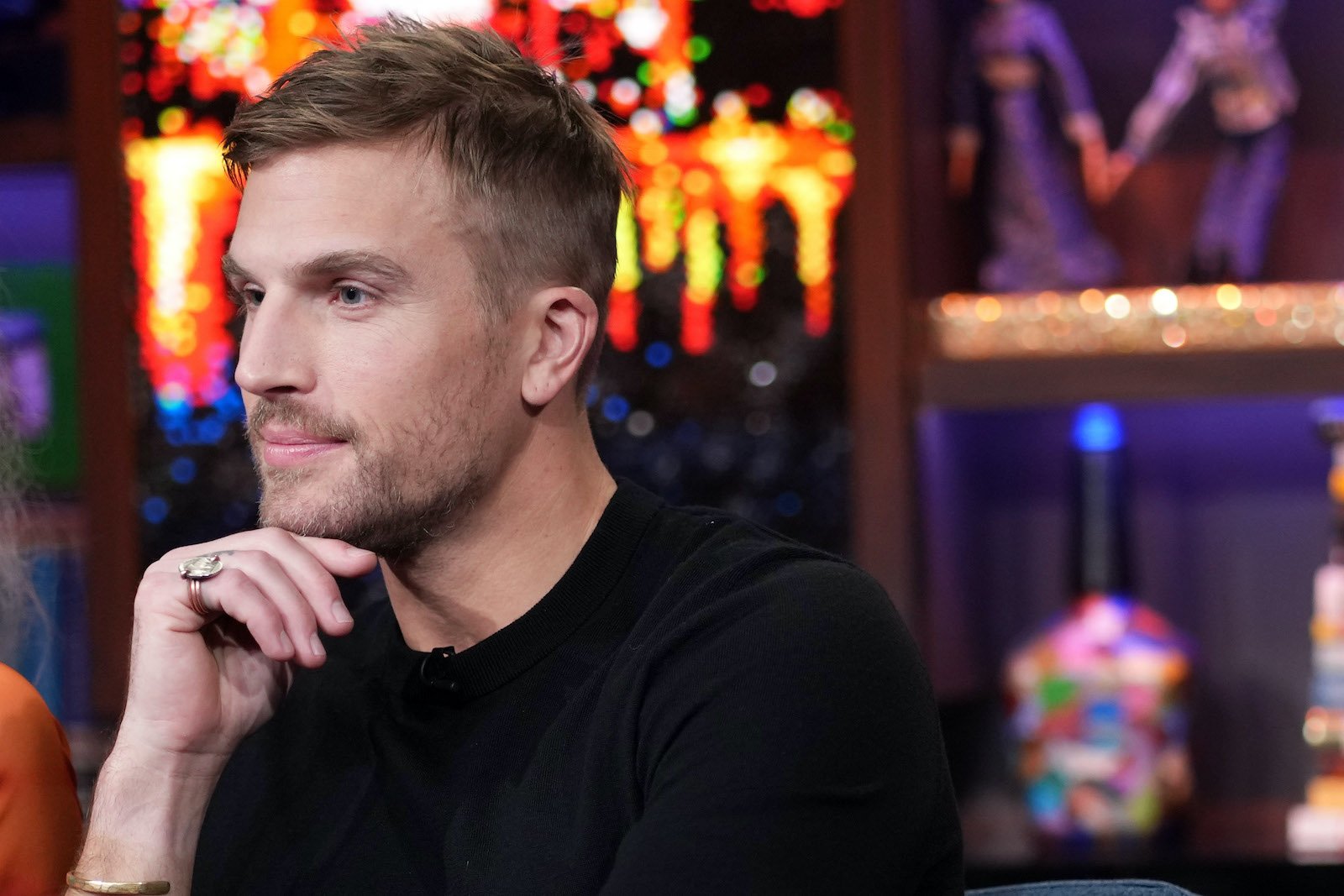 Luke Gulbranson from 'Summer House' props his chin on his hand while on 'WWHL'