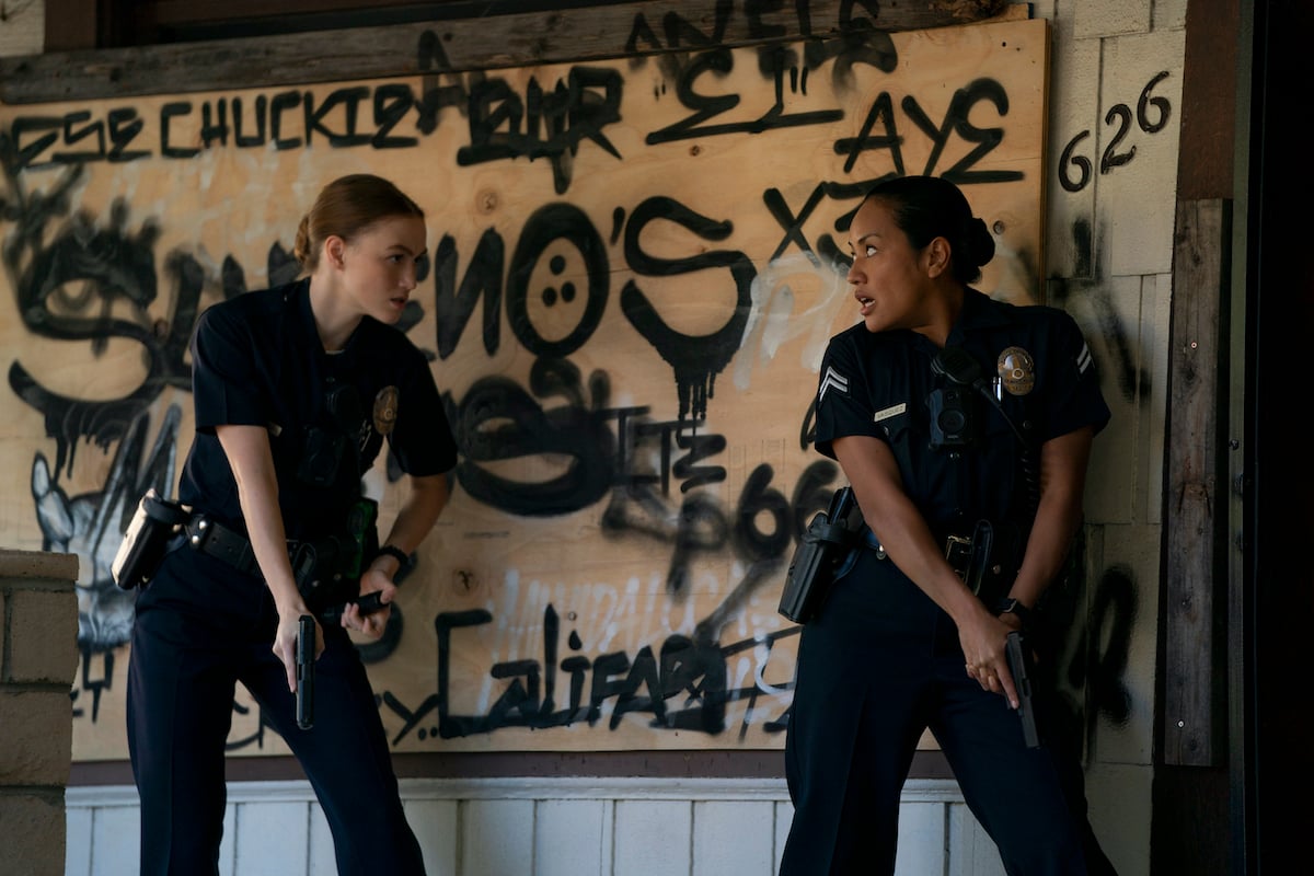 Maddie and Officer Vasquez with guns drawn in front of a graffitied wall in 'Bosch: Legacy'