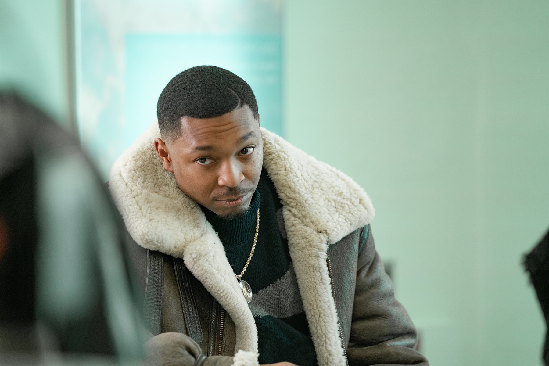 Malcolm Mays wearing a coat and looking off to the side as Lou Lou in 'Power Book III: Raising Kanan'