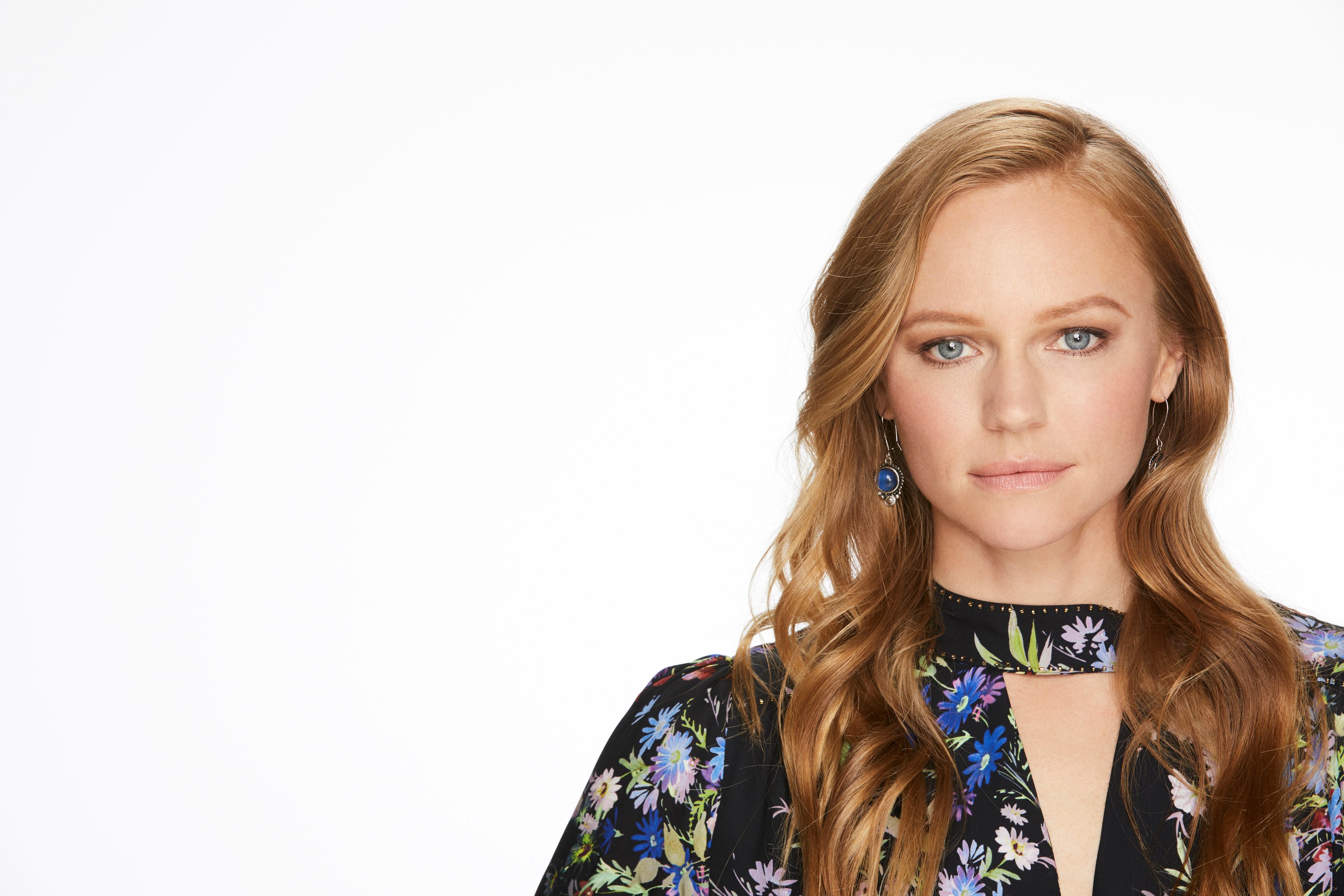 'Days of Our Lives' star Marci Miller wearing a black floral dress and posing in front of a white backdrop.