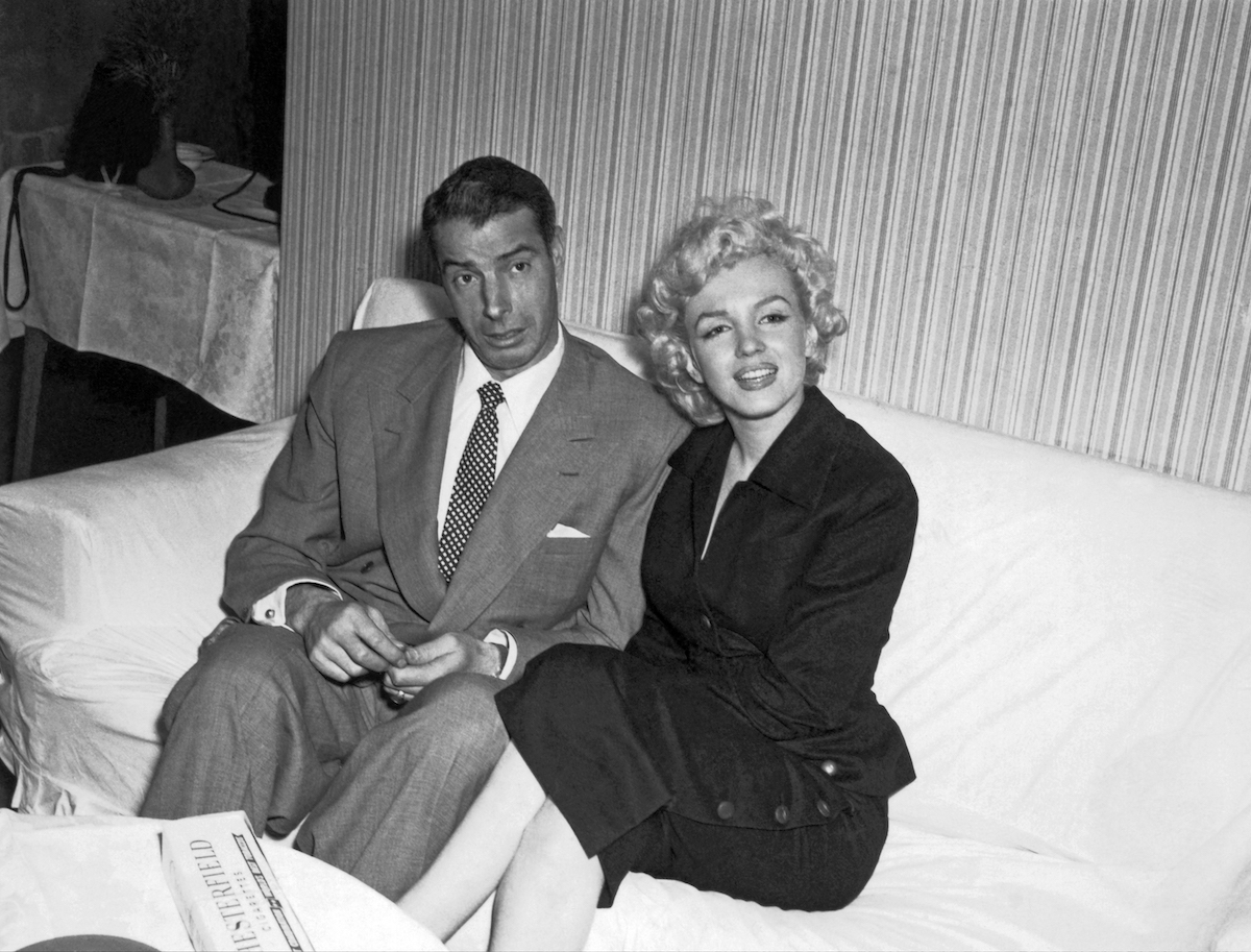 Then-married couple Marilyn Monroe and Joe DiMaggio sit together in 1954