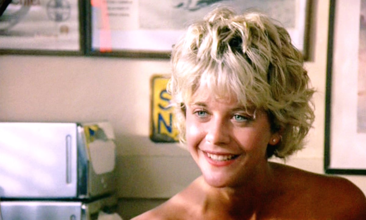 Meg Ryan sits in a restaurant during a scene from Top Gun.