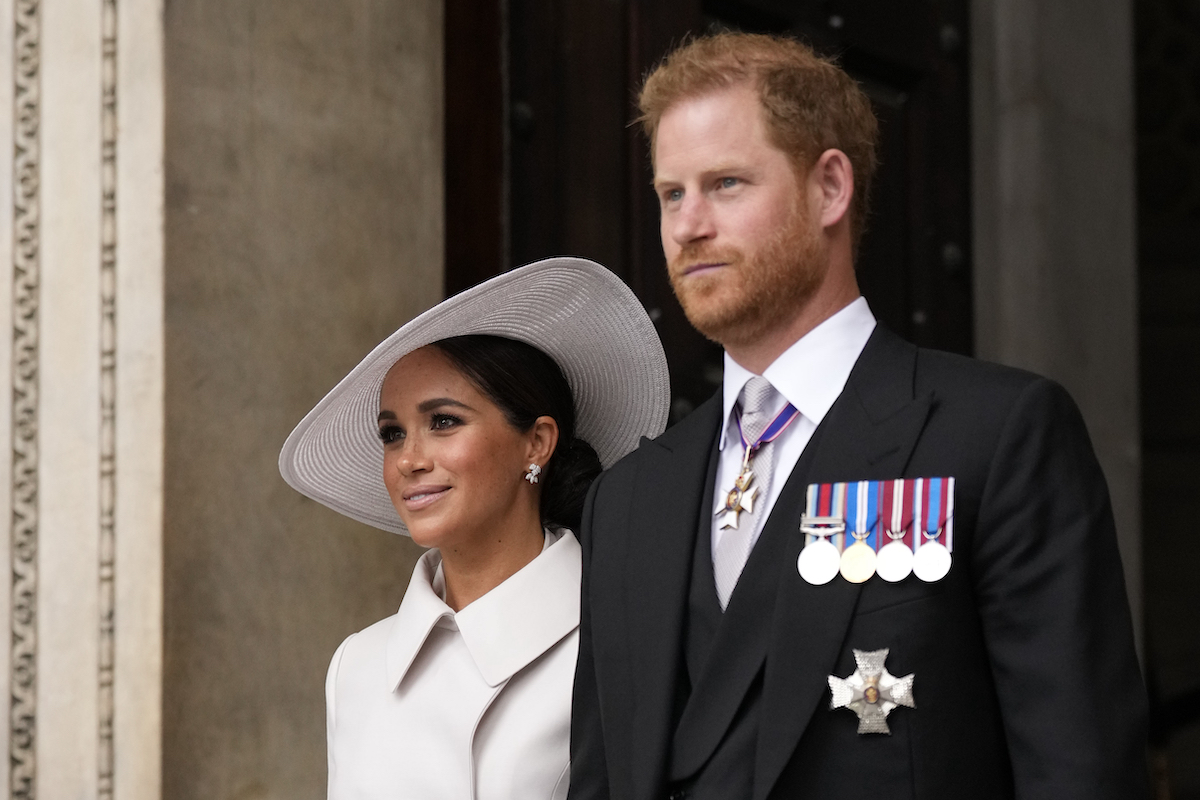 Meghan Markle, who a lip reader says had four words for Prince Harry, stands next to Prince Harry at a jubilee church service