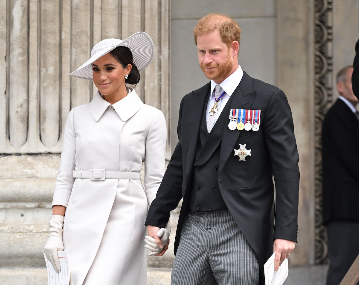 Meghan Markle and Prince Harry, who a royal commentator says didn't get any good 'vibes' from Prince Charles Platinum Jubilee weekend, hold hands