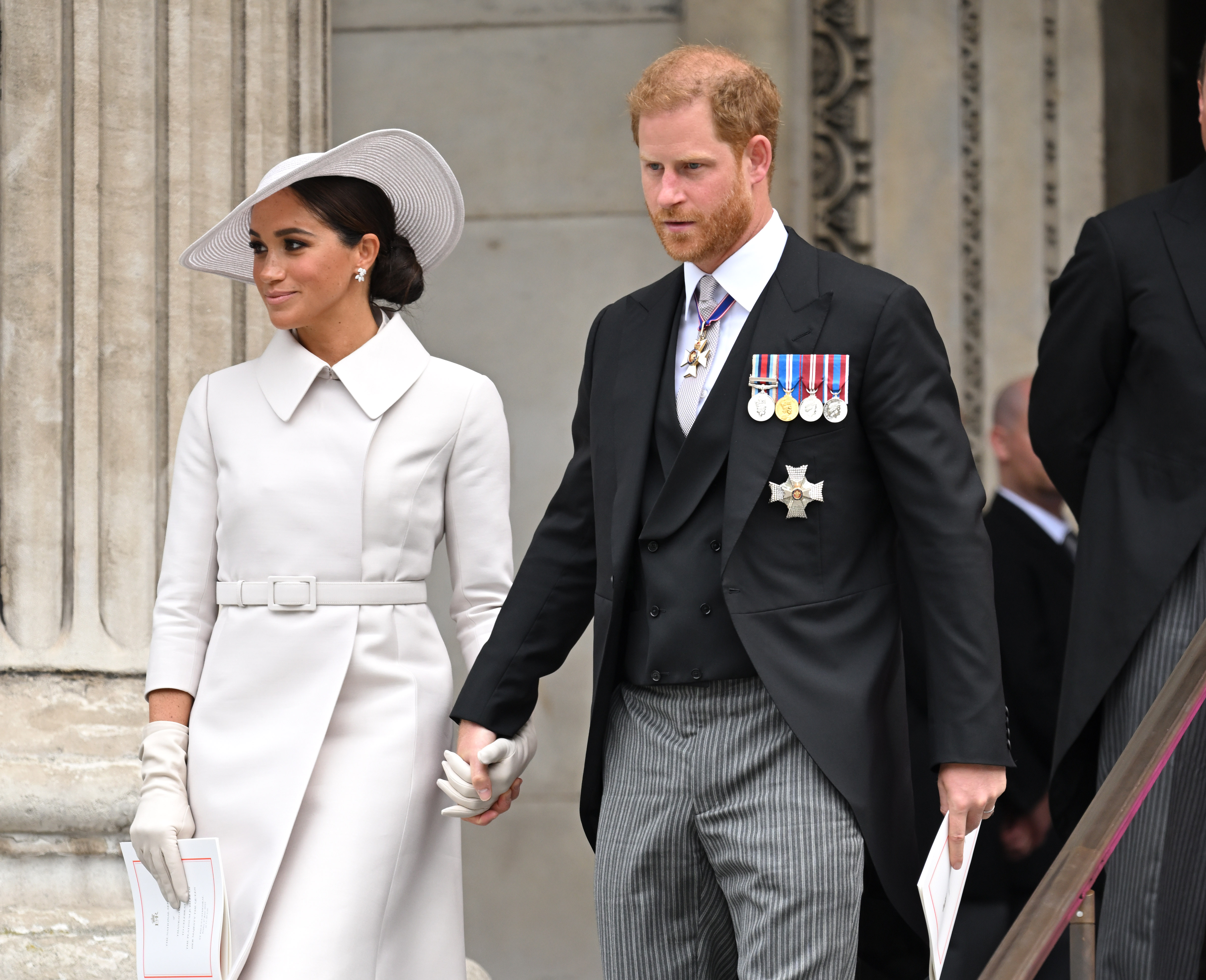 Meghan Markle and Prince Harry, who supposedly had a 'bitter pill' to swallow when Queen Elizabeth didn't take a photo with Lilibet, smile and hold hands during Platinum Jubilee weekend