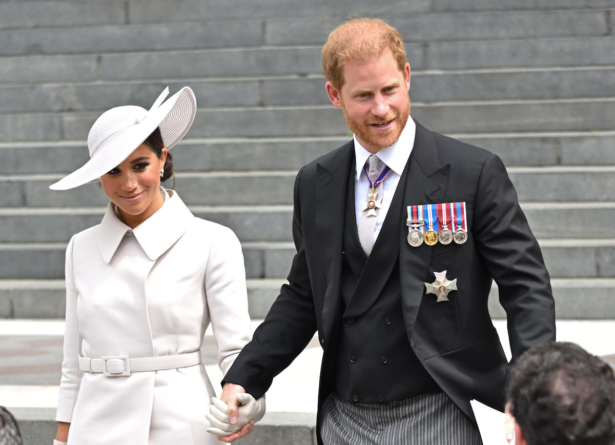 Meghan Markle and Prince Harry, who attended service of Thanksgiving at St. Paul's Cathedral, smile as they look on and hold hands