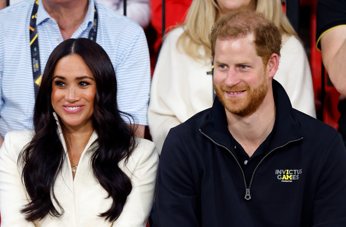 Meghan Markle and Prince Harry, who hosted Lilibet's first birthday party, smile and look on 