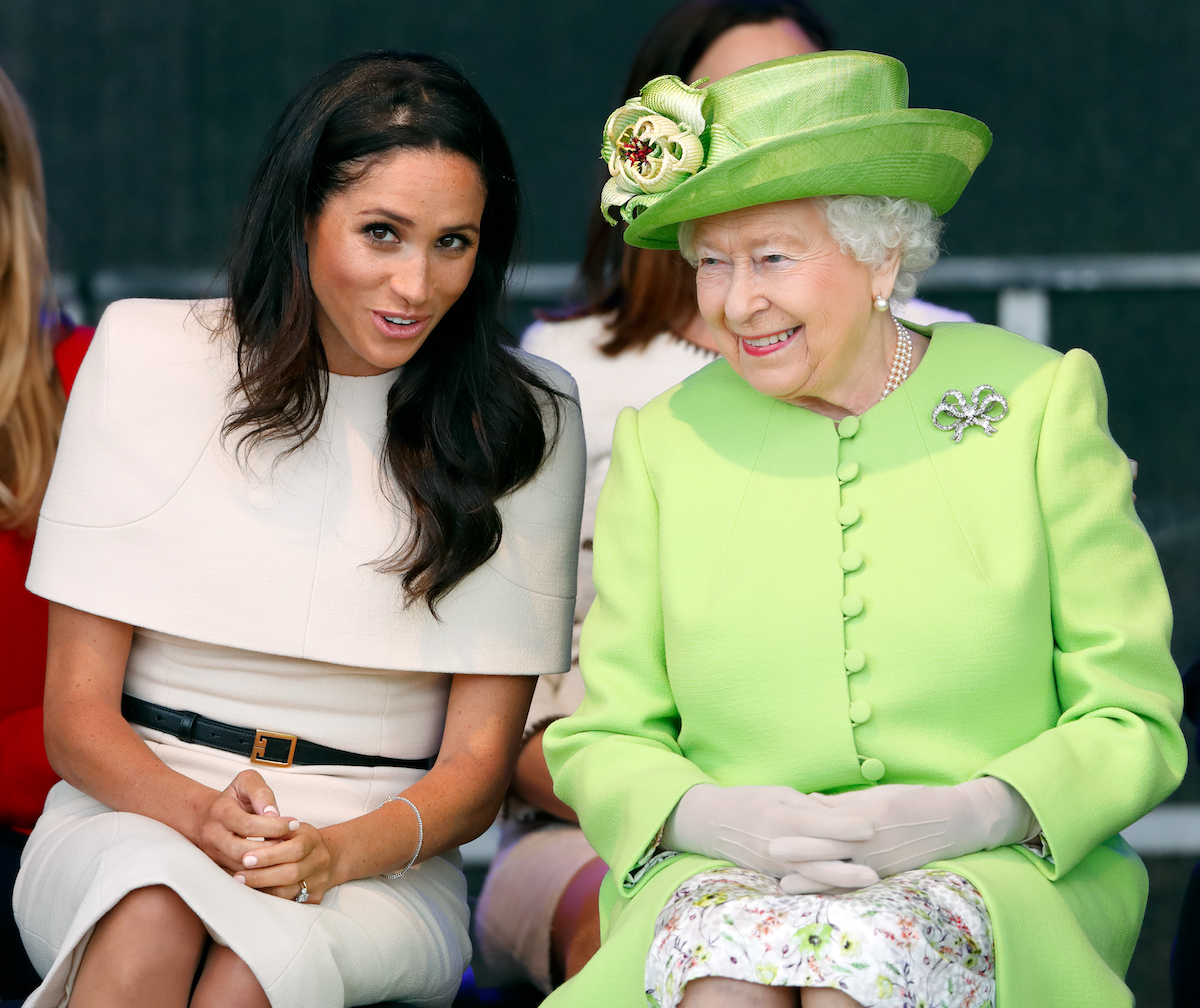 Meghan Markle and Queen Elizabeth, who a royal expert says won't release the Meghan Markle bullying allegations report because she doesn't want 'more drama,' look on