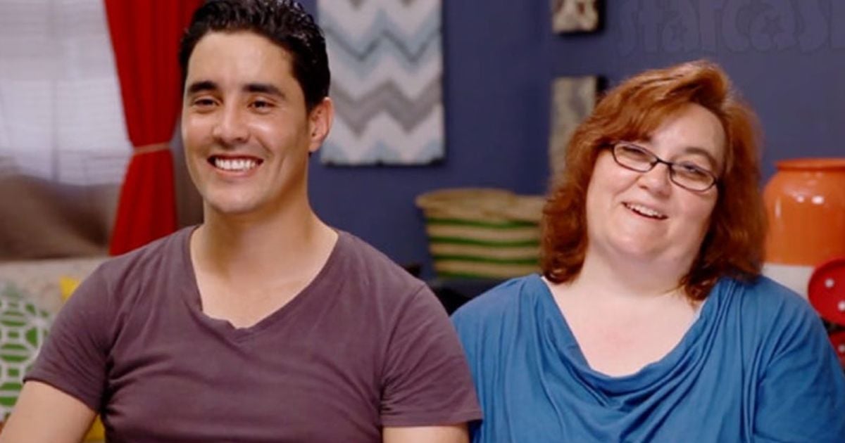 Mohamed Jbali and Danielle Mullins sit next to each other, smiling, on the set of '90 Day Fiancé' Season 2 on TLC.