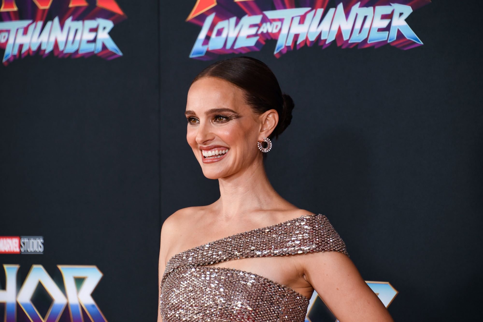 Natalie Portman, who stars as Jane Foster in 'Thor: Love and Thunder,' wears a pink sparkly off-the-shoulder dress.