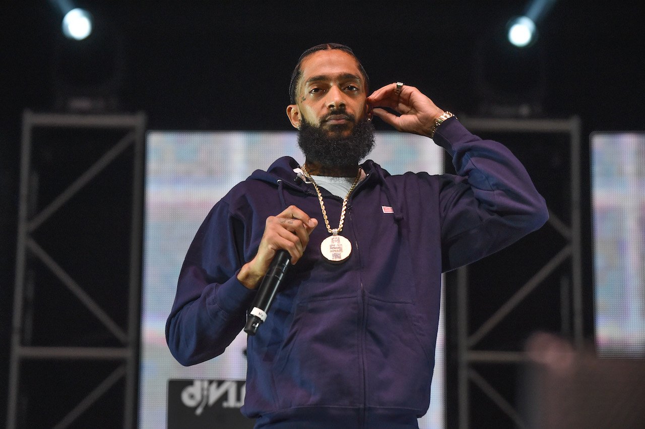 Nipsey Hussle on stage; the woman in the getaway car of Hussle's murder testified in the alleged killer's murder trial