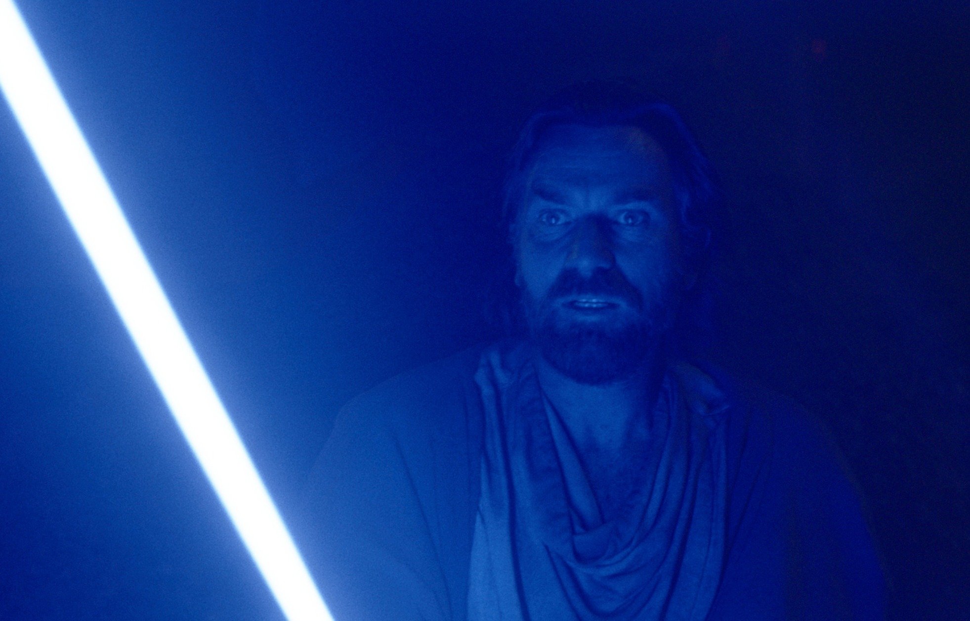 Ewan McGregor in 'Obi-Wan Kenobi,' which has a June 8 release date for episode 4. He's holding a blue lightsaber, and it's making everything around him blue.