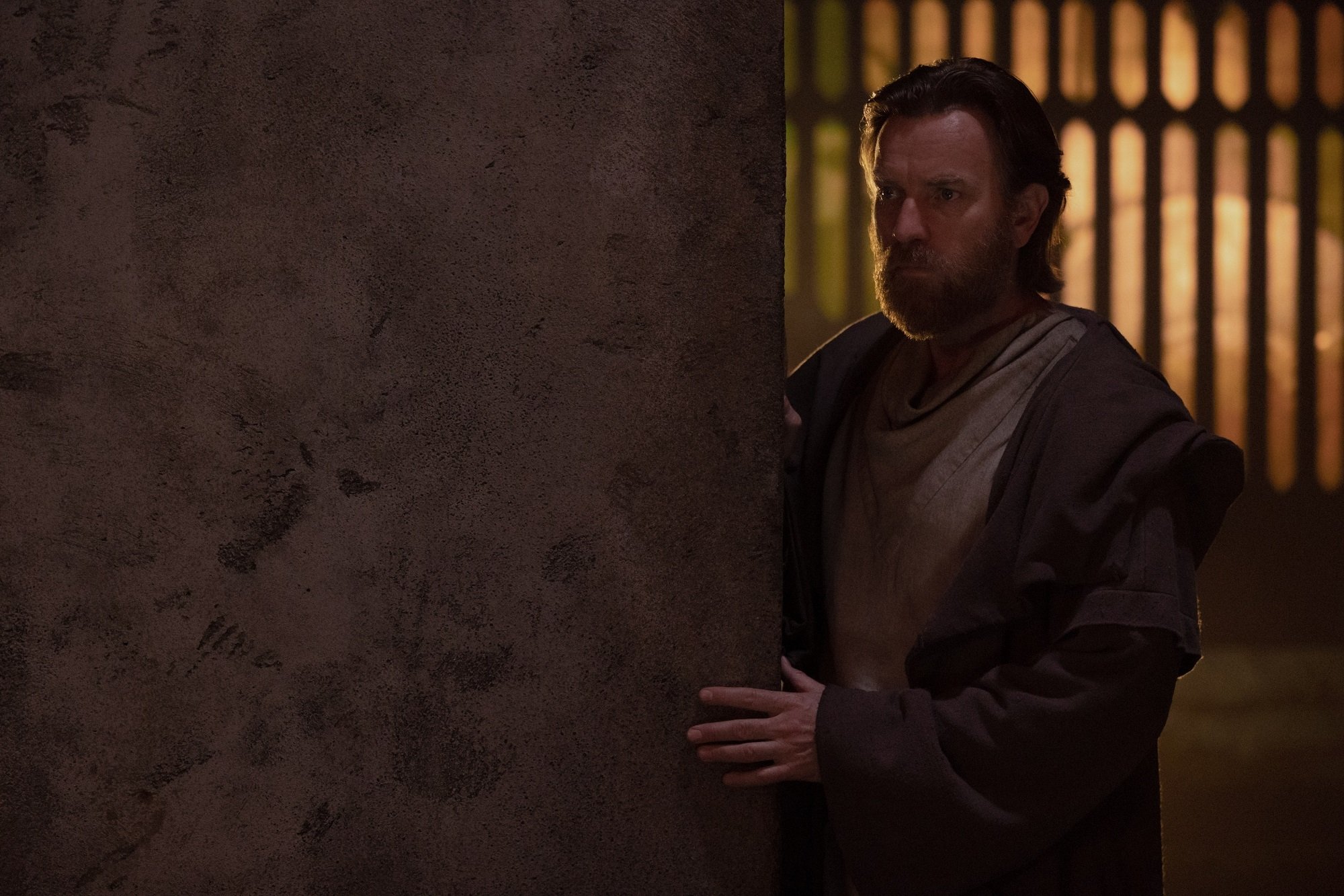 Obi-Wan Kenobi stands behind a wall in the Disney+ series 'Obi-Wan Kenobi'