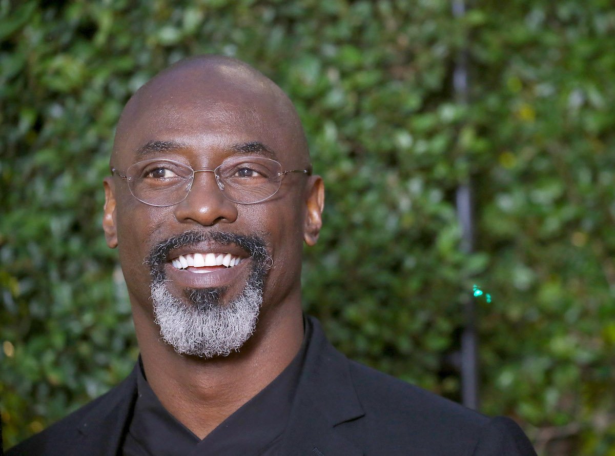 'P-Valley' actor Isaiah Washington appears at a media event. He has on a black outfit and looks off to the side as a photographer takes his photo.