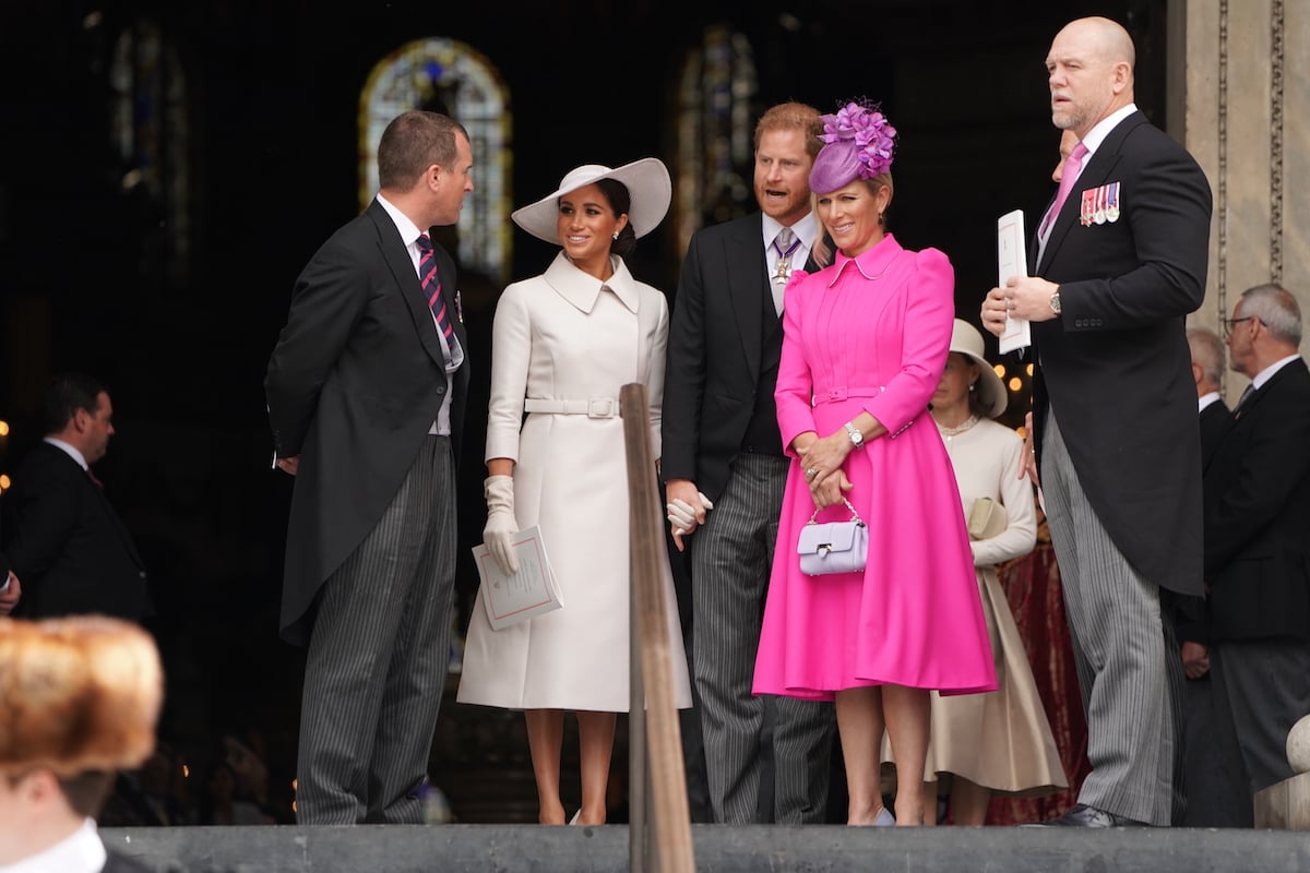 Mike Tindall, who a body language expert says had a moment of 'awkwardness' with Prince Harry at the jubilee service, stands next to Zara Tindall, Prince Harry, Meghan Markle and Peter Phillips