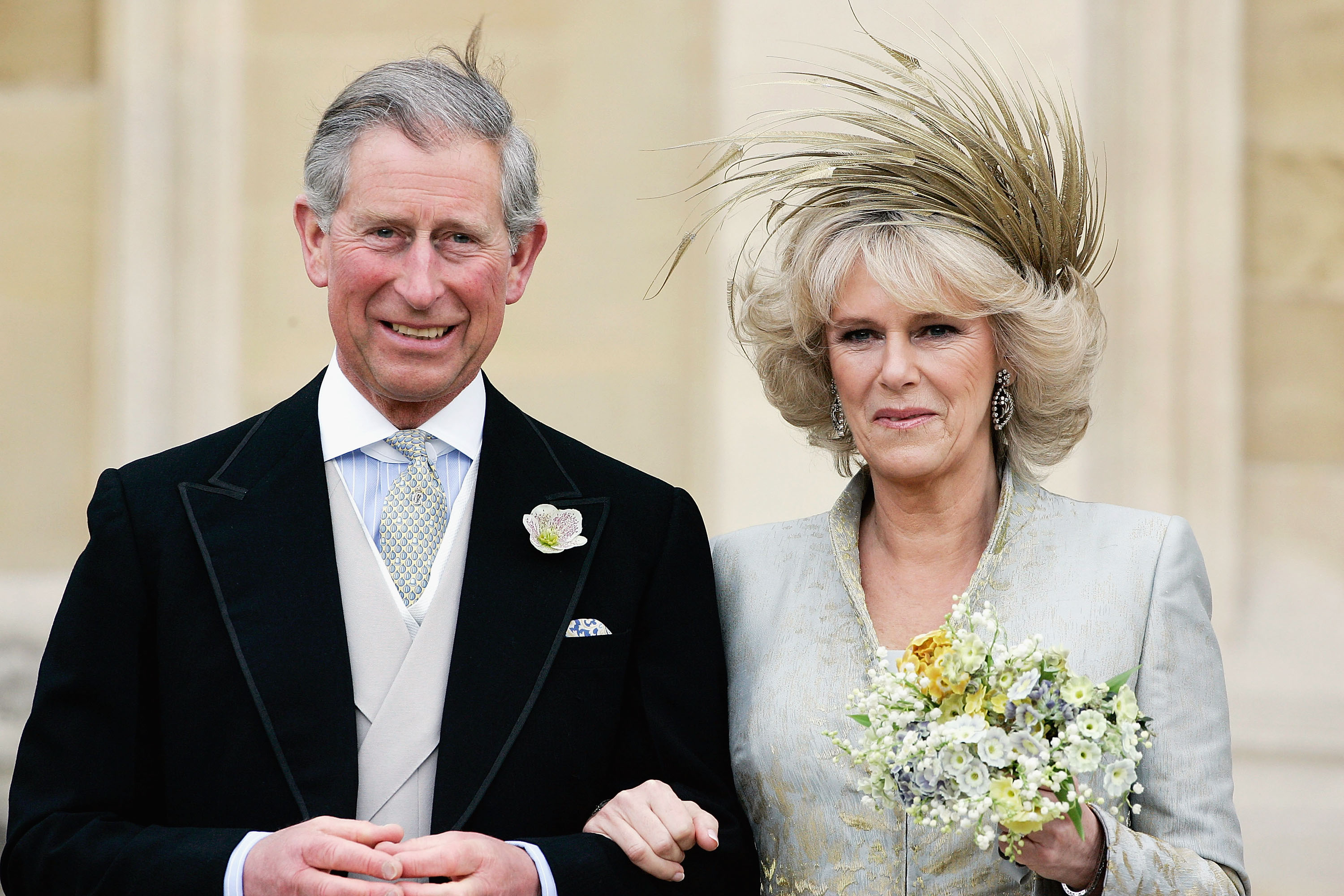 Prince Charles and Camilla Parker Bowles standing together with Camilla holding flowers