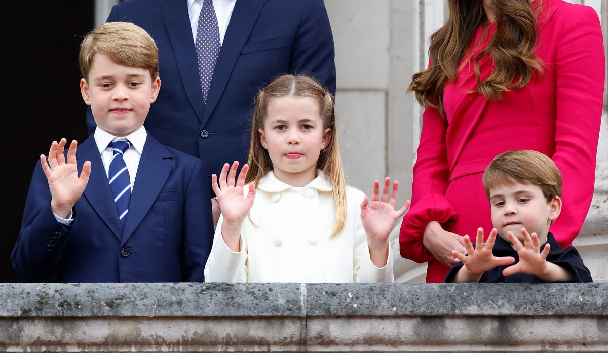 Prince George, Princess Charlotte, and Prince Louis, who won't be going to the same school as his siblings, waving from the balcony of Buckingham Palace