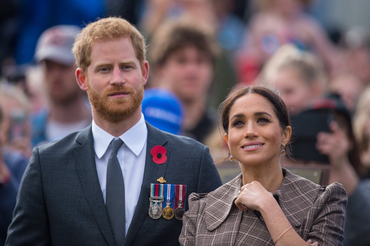 Prince Harry and Meghan Markle, who a royal author says would've likely been granted a break from royal duties by Queen Elizabeth II, look on 