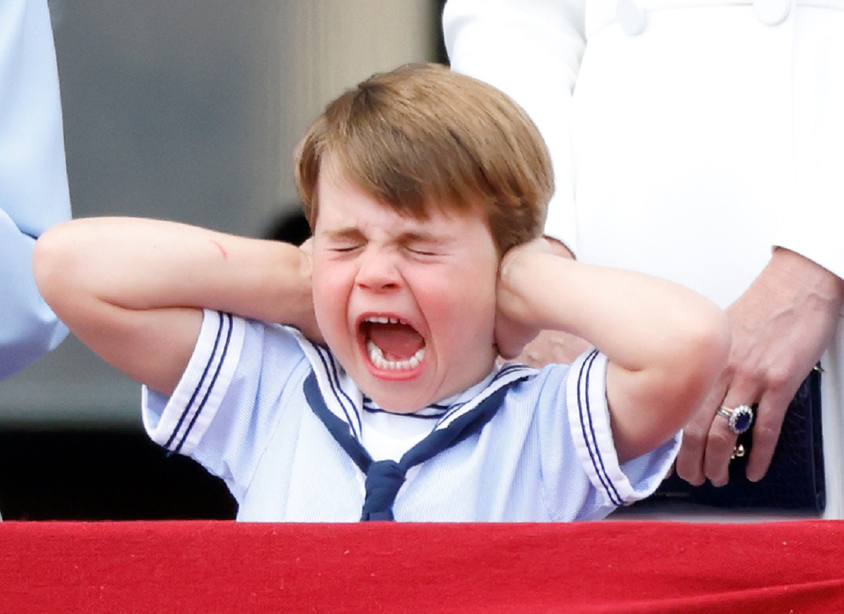 Prince Louis covers his ears whilst watching a flypast from the balcony of Buckingham Palace