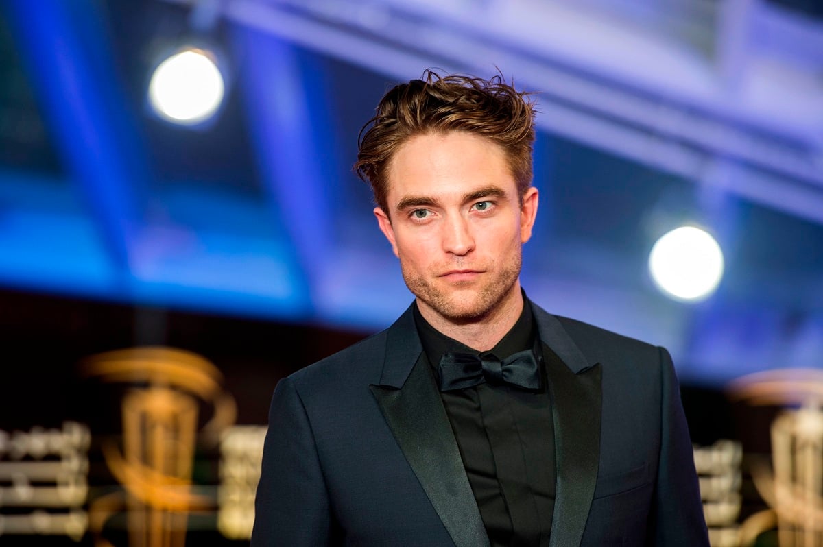 Robert Pattinson posing while wearing a suit.