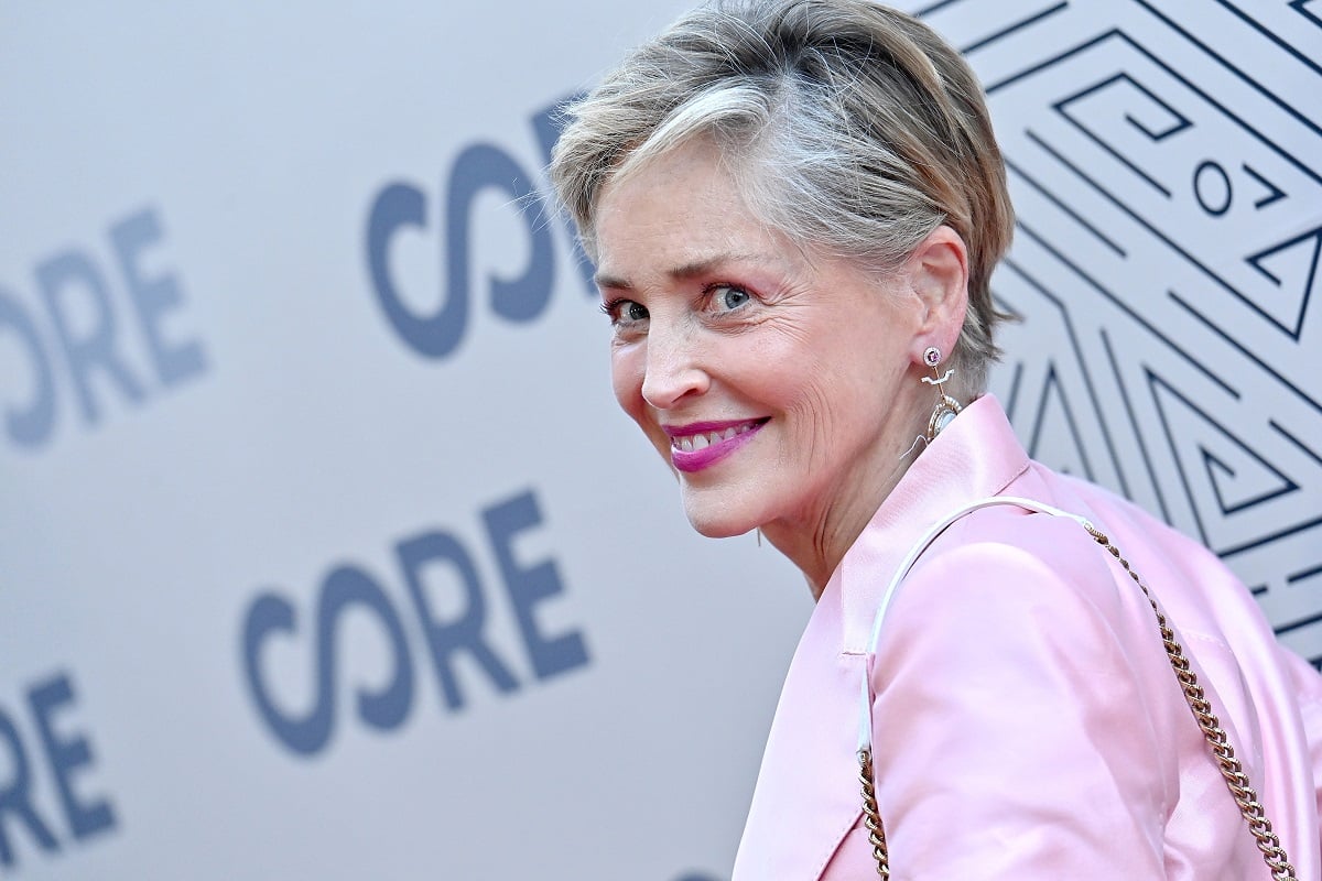 Sharon Stone smiling while wearing a pink suit.