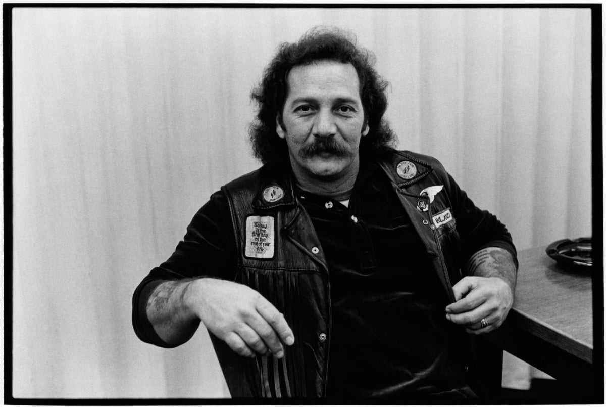 Portrait of biker and Sons of Anarchy actor Sonny Barger (born Ralph Barger) as he sits at a table in San Francisco, California on January 1979. Barger has a mustache and wears a biker kutte.