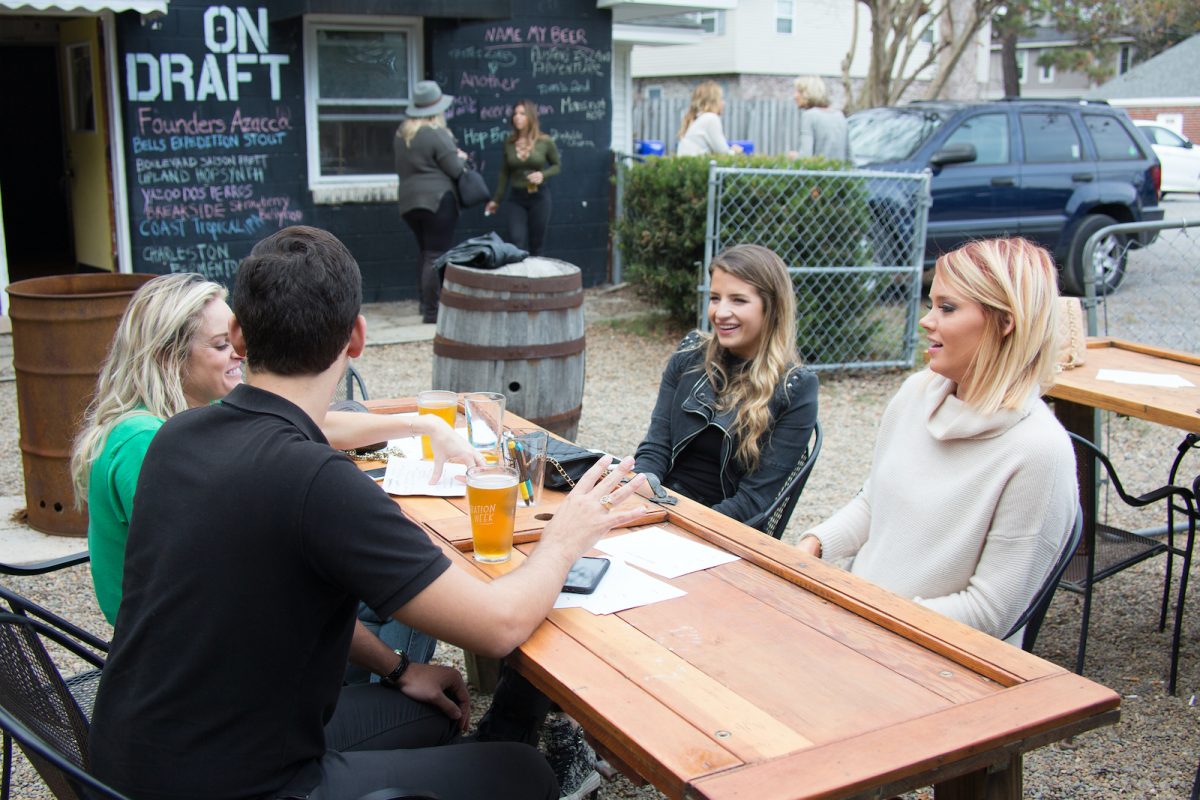 Danni Baird, Naomie Olindo und Kathryn Dennis trinken Bier an einem Tisch draußen bei „Southern Charm“.