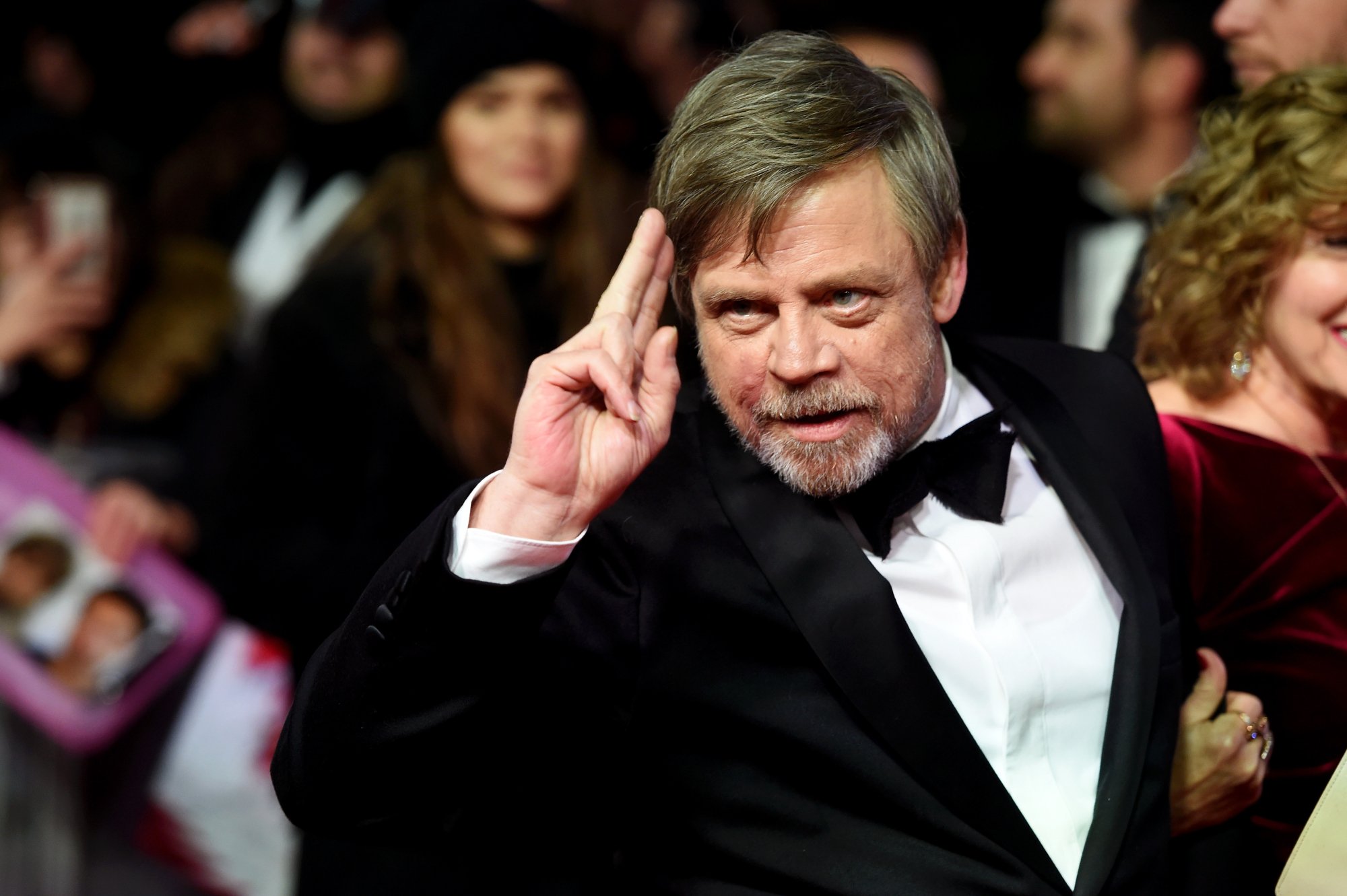 'Star Wars' actor Mark Hamill wearing a tux saluting with two of his fingers 