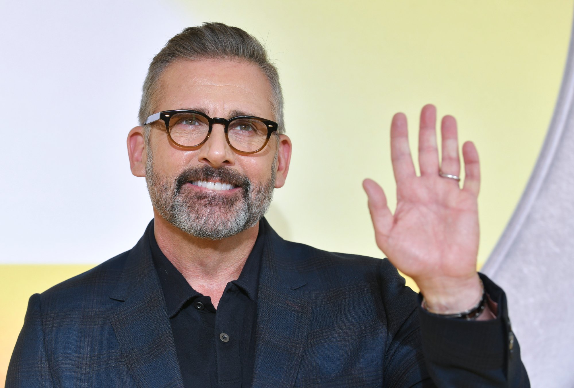Steve Carell, who voiced in the 'Despicable Me' movies. Carell holds his hand up, waving with a smile