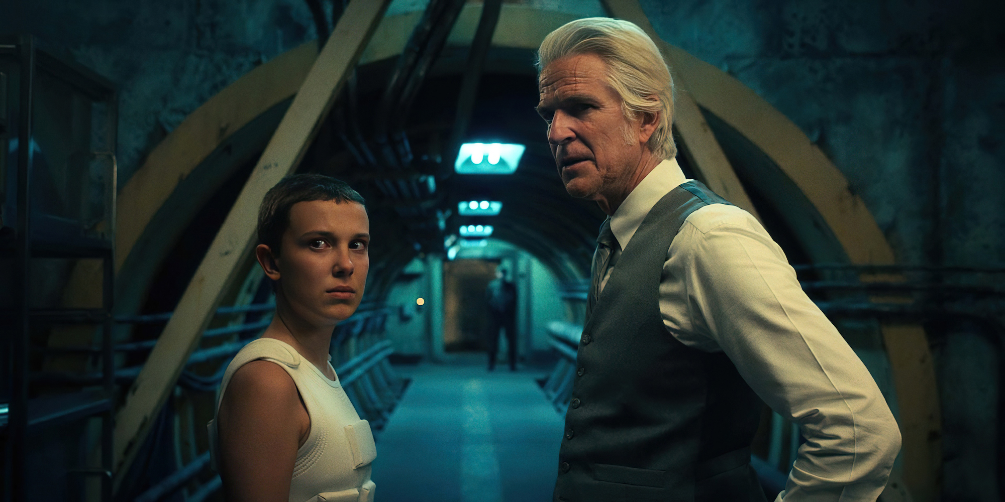 The 'Stranger Things 4' Part 2 trailer reveals that Dr. Brenner doesn't believe Eleven is ready yet. Both Matthew Modine and Millie Bobby Brown are seen here in a production still.