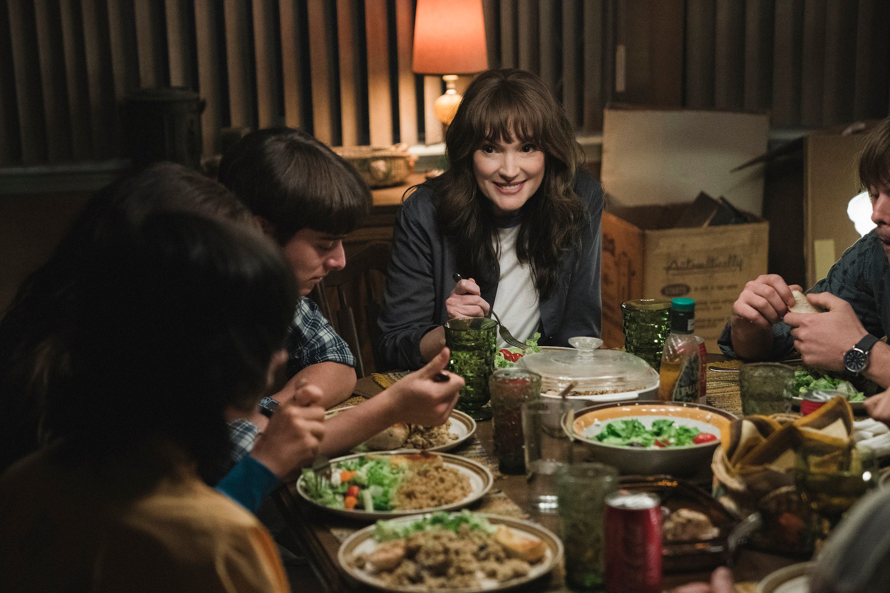 Noah Schanpp as Will Byers and Winona Ryder as Joyce Byers eating dinner together in 'Stranger Things' Season 4