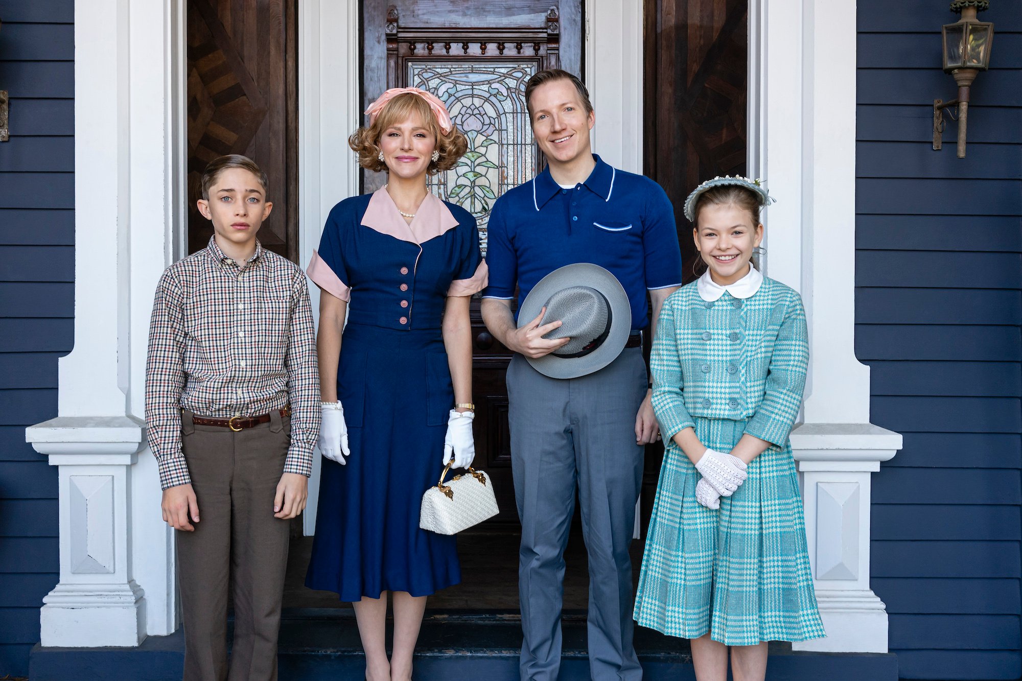 'Stranger Things 4' characters Henry Creel, Virginia Creel, Victor Creel, and Alice Creel stand in front of their home in a production still.
