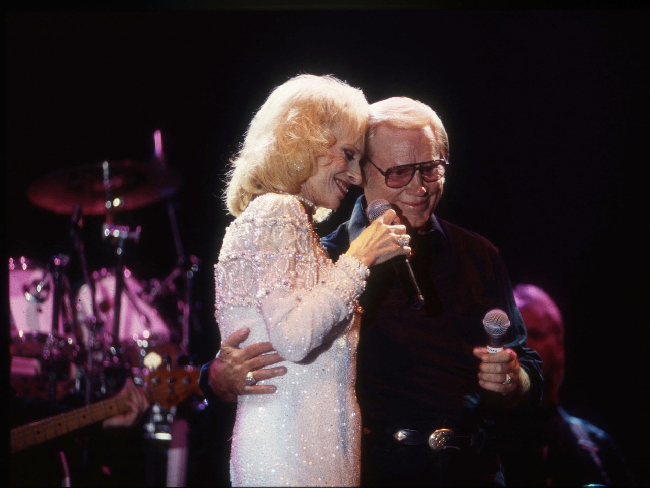 Tammy Wynette and George Jones, pictured embracing during a performance, had a hard time because of his drinking