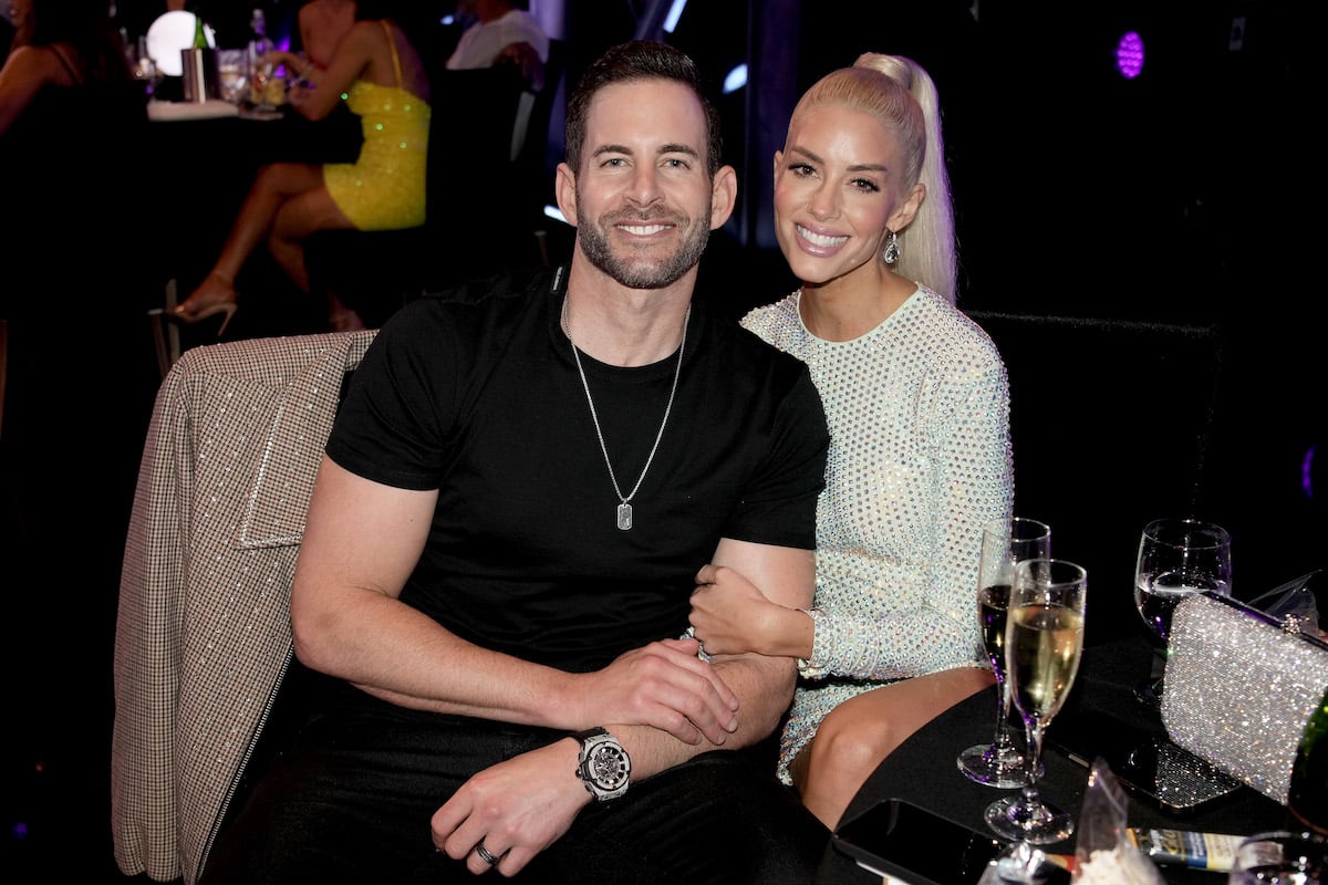 Tarek El Moussa and Heather Rae Young smile and pose together at an event.
