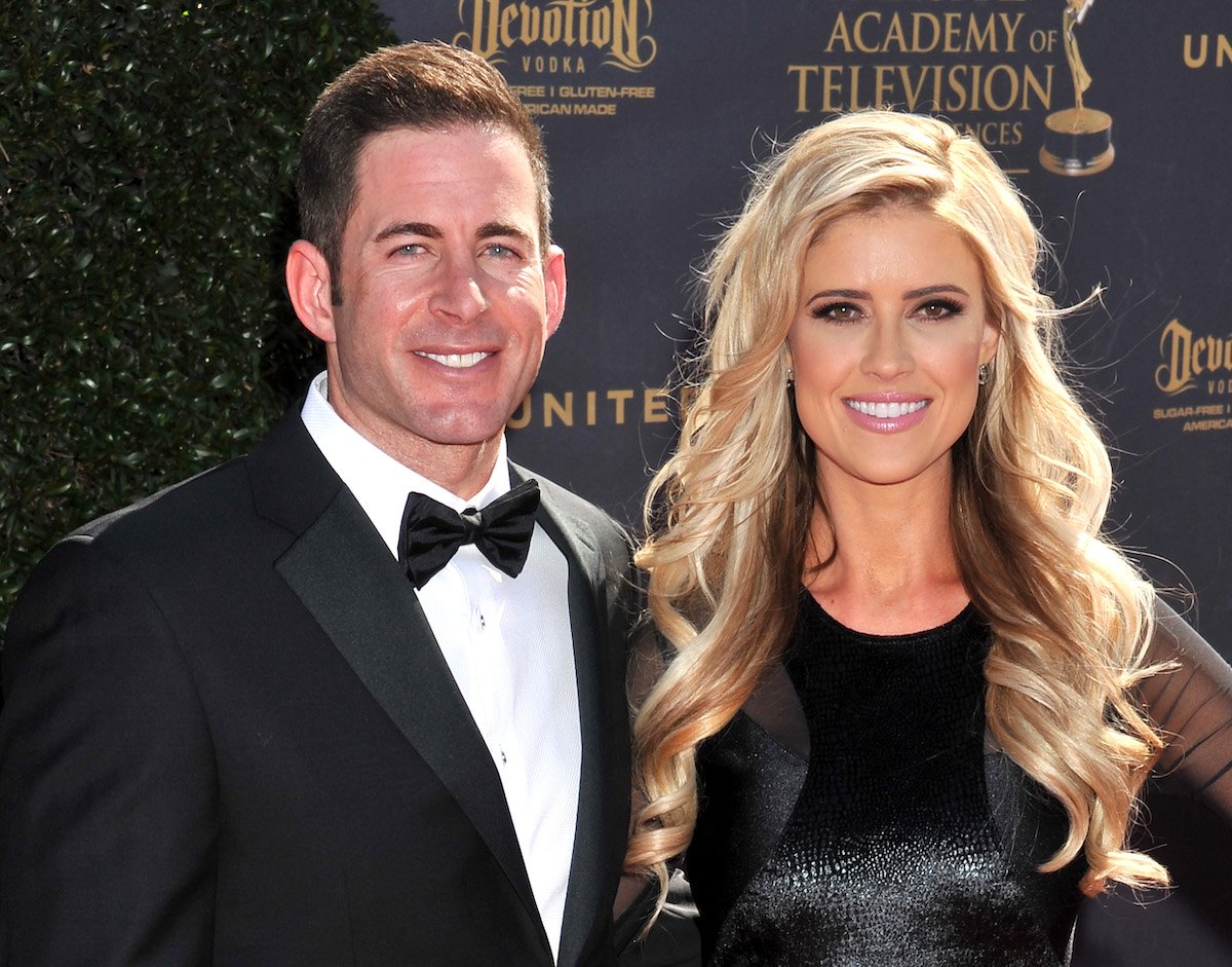 Tarek El Moussa and Christina Hall smile and pose together at an event.