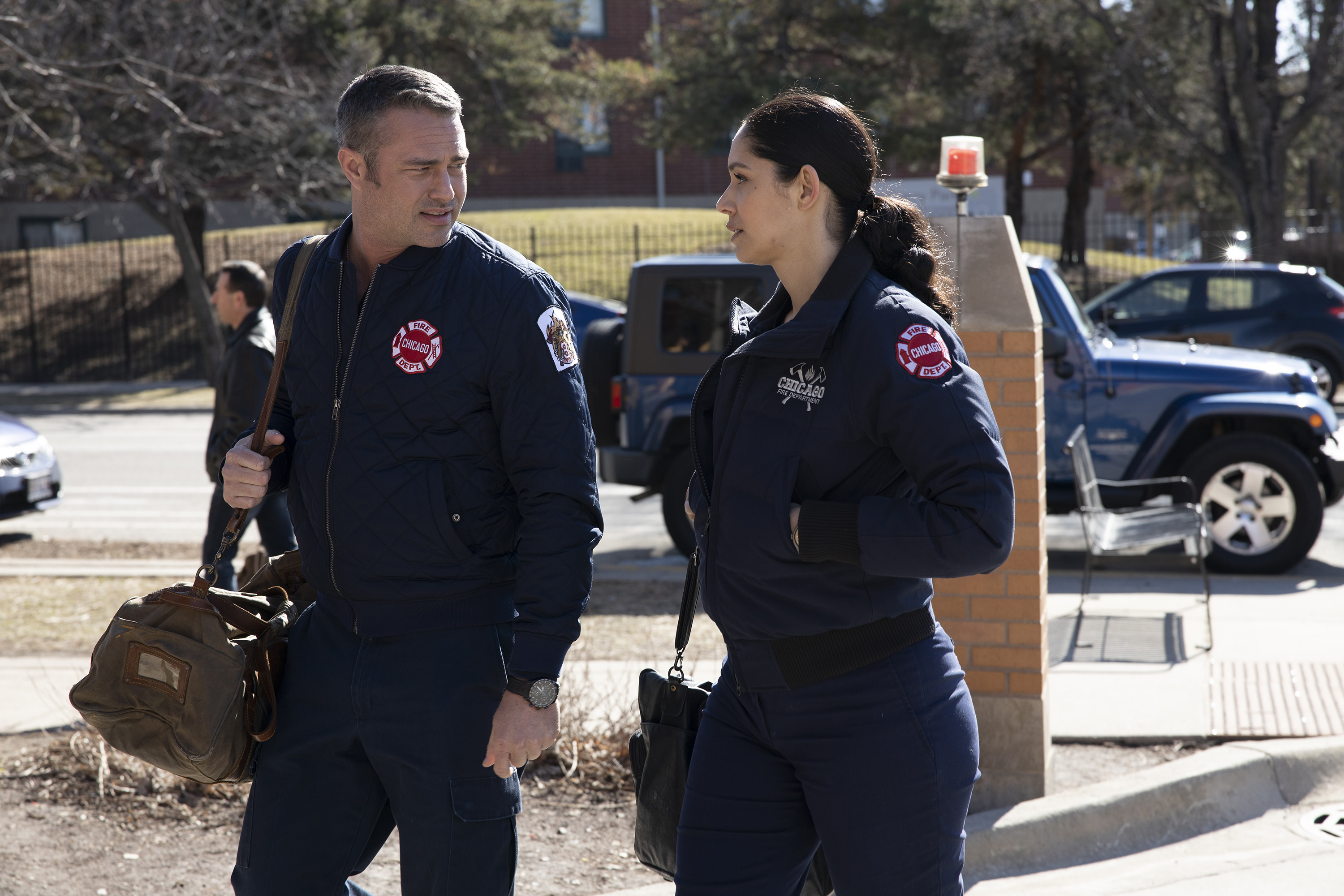 Taylor Kinney and Miranda Rae Mayo walk together during a Chicago Fire scene.