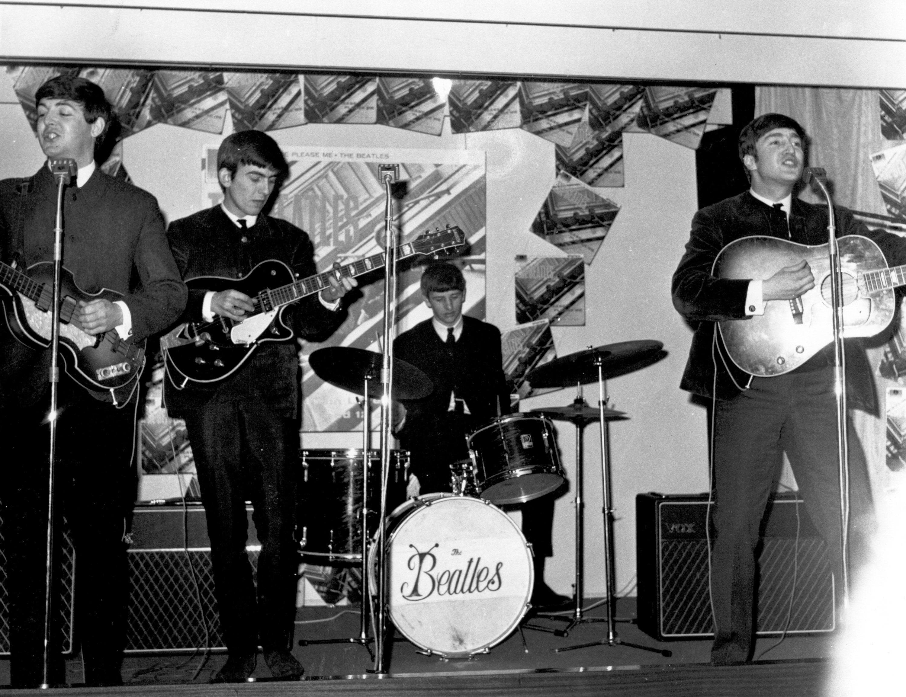 The Beatles’ Paul McCartney, George Harrison, Ringo Starr, and John Lennon playing songs on a stage