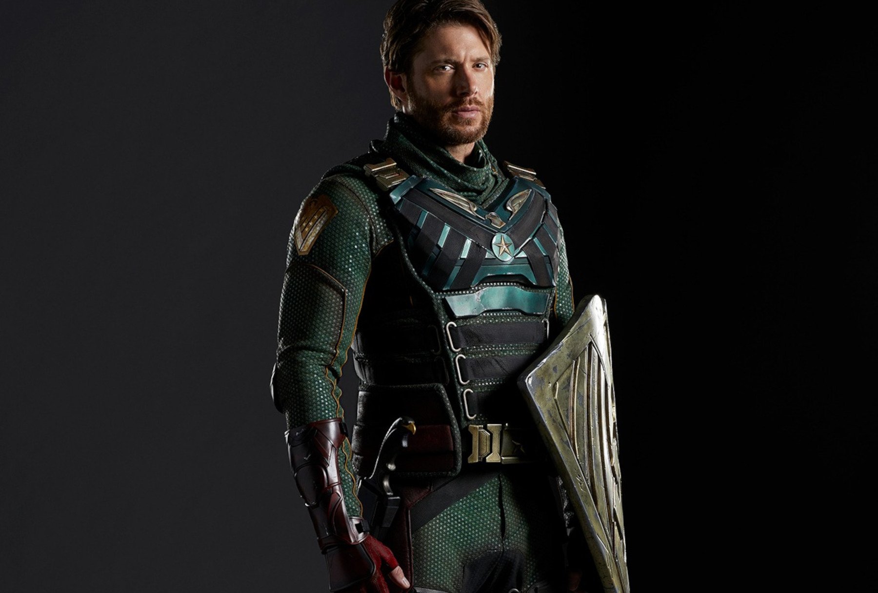 Jensen Ackles as Soldier Boy in 'The Boys.' He's wearing a green and black suit and holding a shield.
