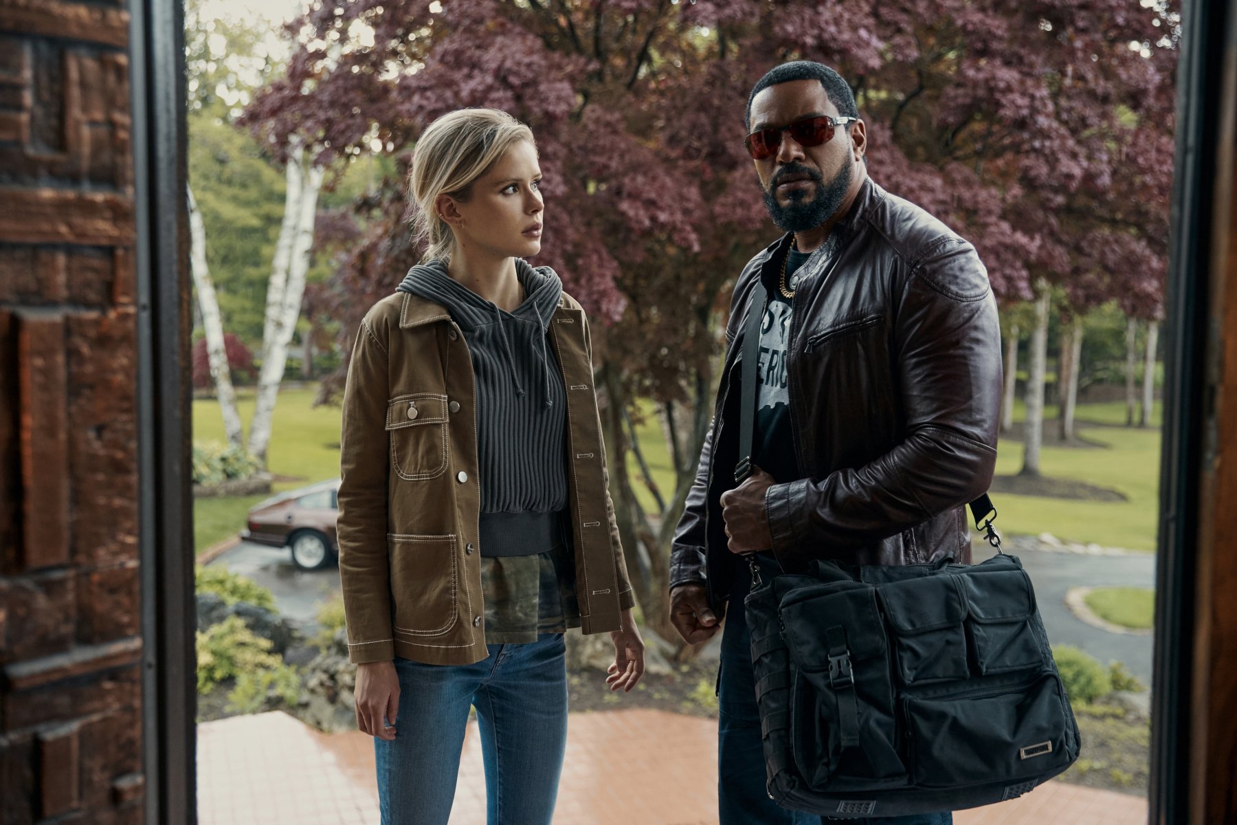 Cast members Erin Moriarty and Laz Alonso as Annie January and Mother's Milk in 'The Boys' Season 3's 'Herogasm' episode. They're standing in a doorway, and Annie is looking at Mother's Milk. Both have concerned expressions.