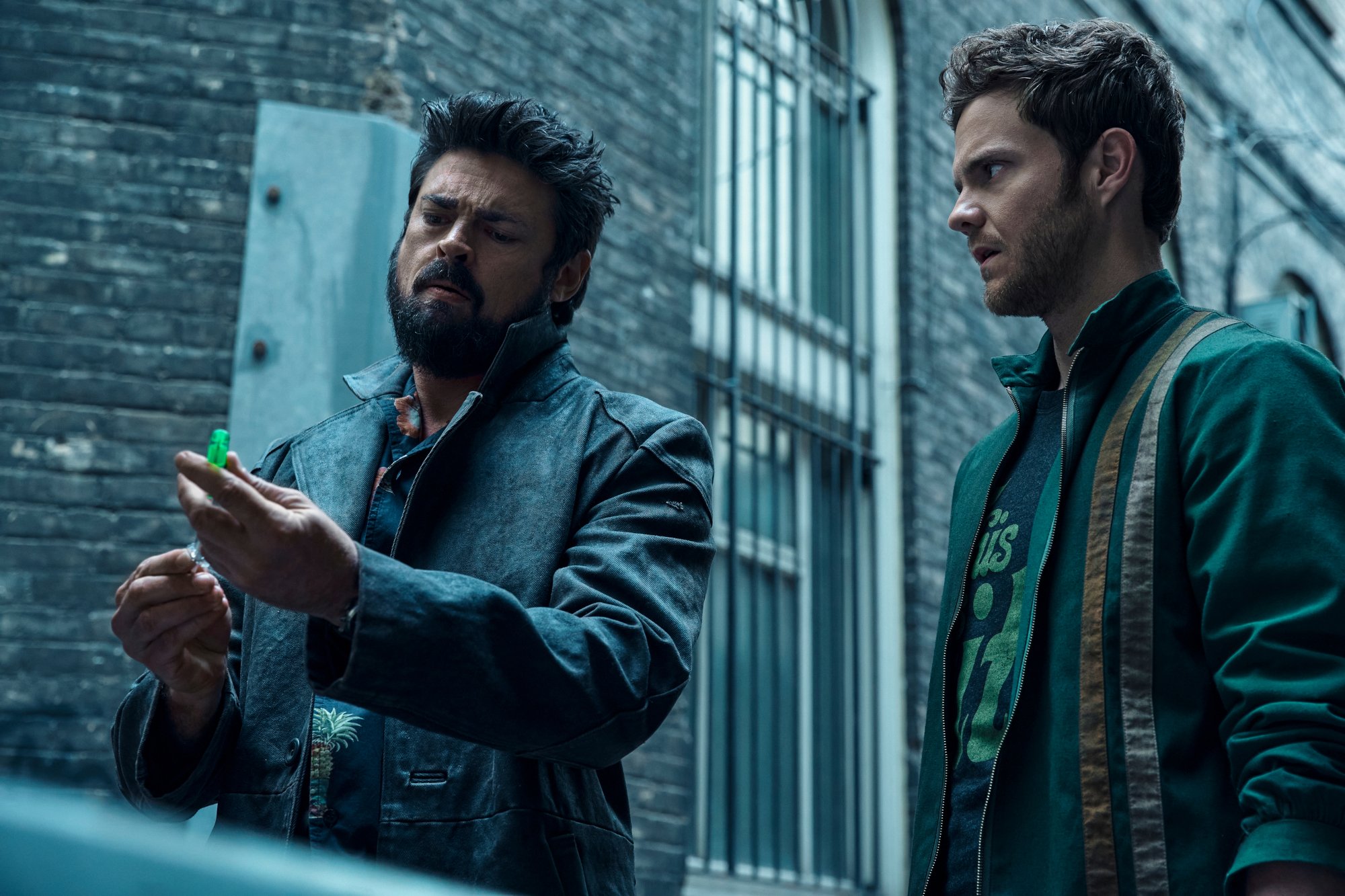 Karl Urban and Jack Quaid as Billy Butcher and Hughie Campbell in 'The Boys' Season 3 Episode 5, which will be followed by episode 6 on its June 24 release date. Butcher and Hughie are standing behind the trunk of a car, and Butcher is filling a syringe with Temp V.