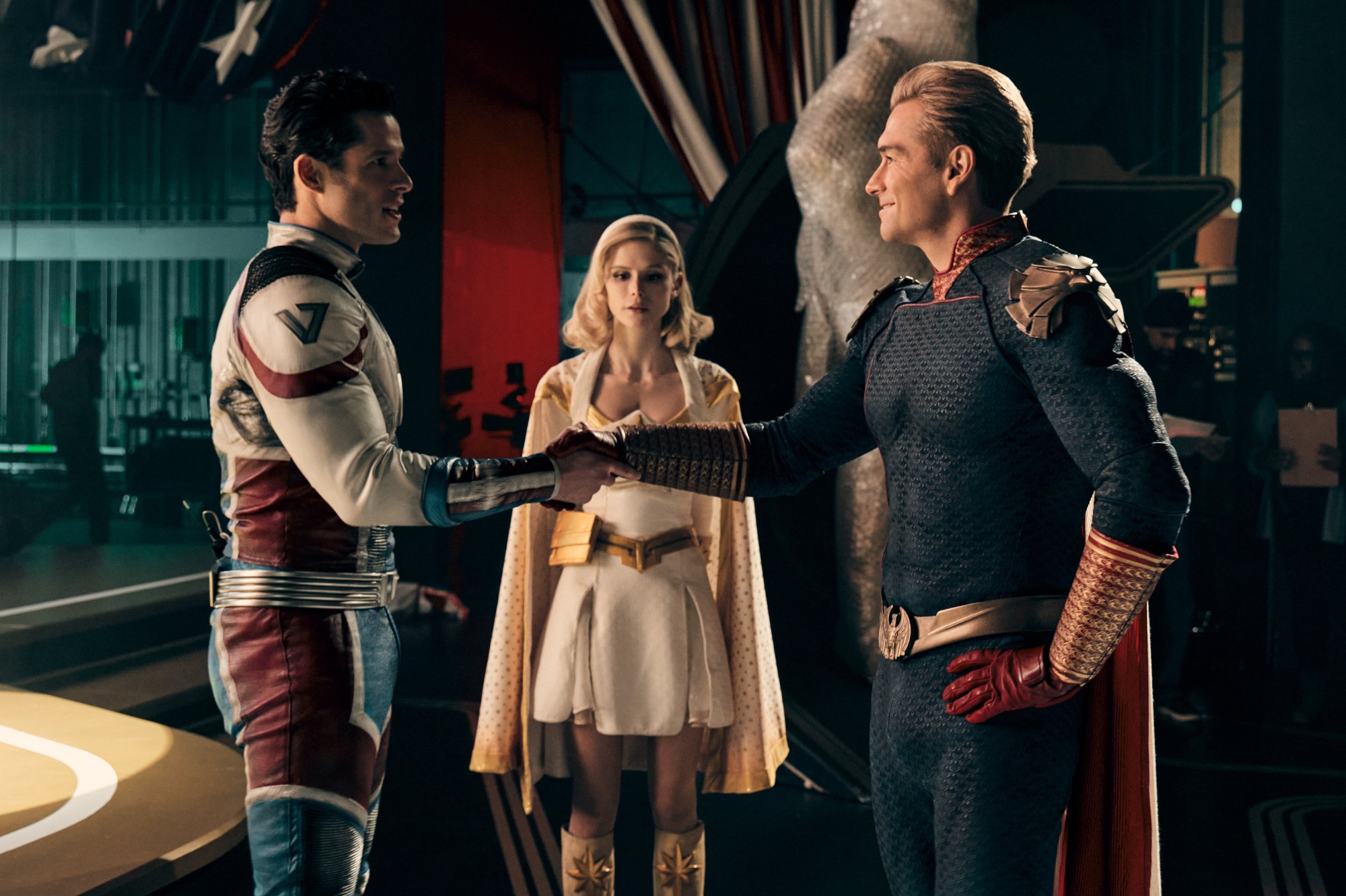Miles Gaston Villanueva, Erin Moriarty, and Antony Starr as Supersonic, Starlight, and Homelander in the early episodes of 'The Boys' Season 3. Supersonic and Homelander are shaking hands, and Starlight stands between them.