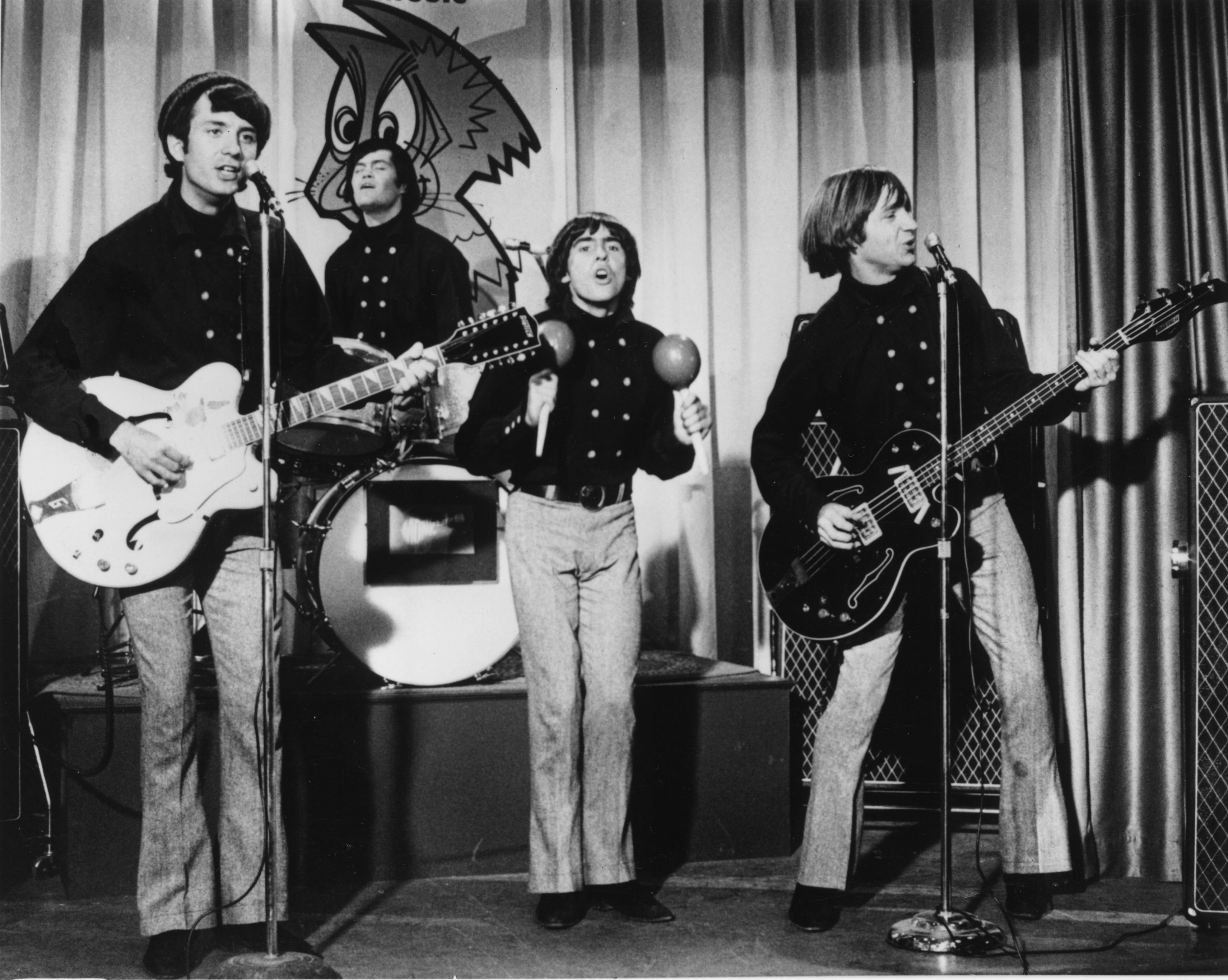 The Monkees' Mike Nesmith, Micky Dolenz, Davy Jones, and Peter Tork paying songs on a stage