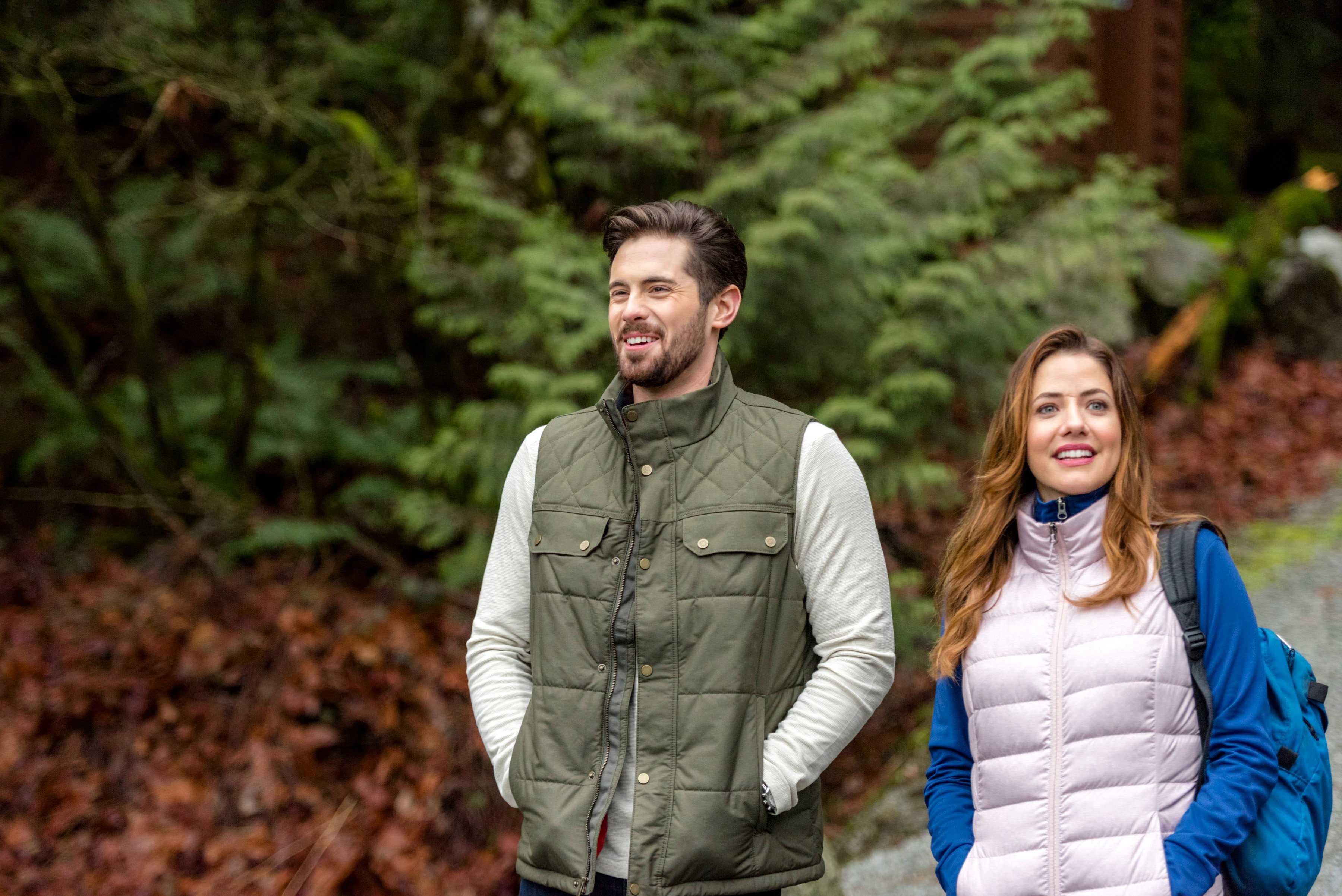 Chris McNally and Julie Gonzalo, both wearing outdoor attire, in the 2018 Hallmark movie 'The Sweetest Heart'