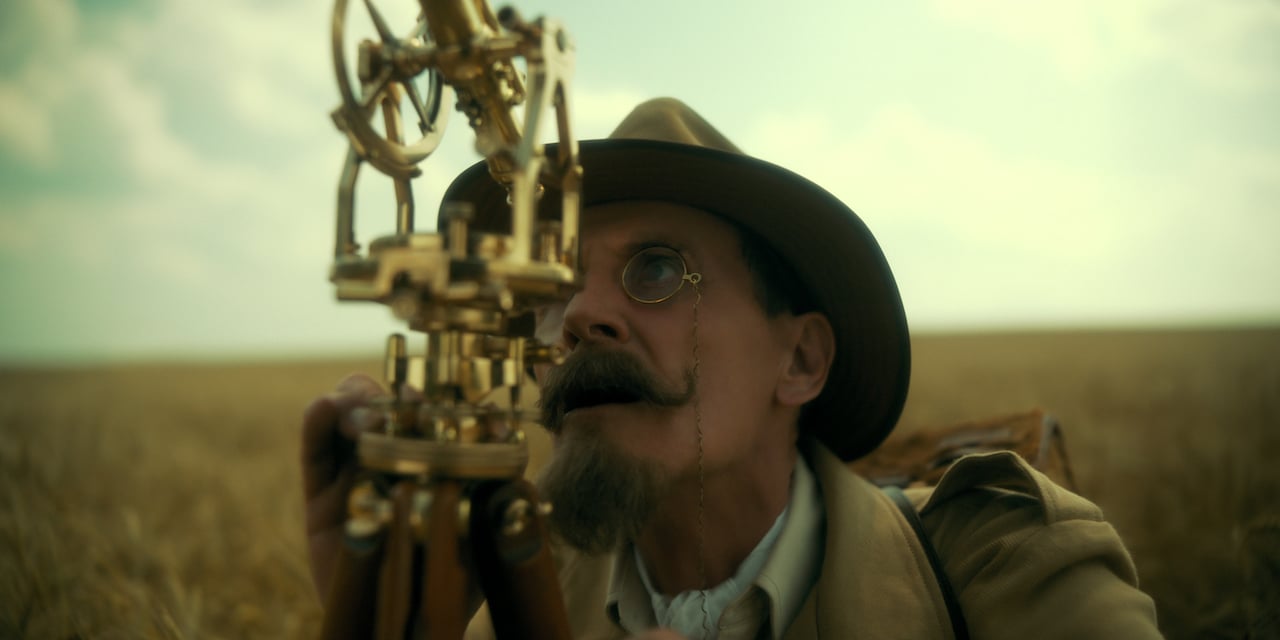 Colm Feore as Reginald Hargreeves looks through a telescope in a field in 'The Umbrella Academy'.