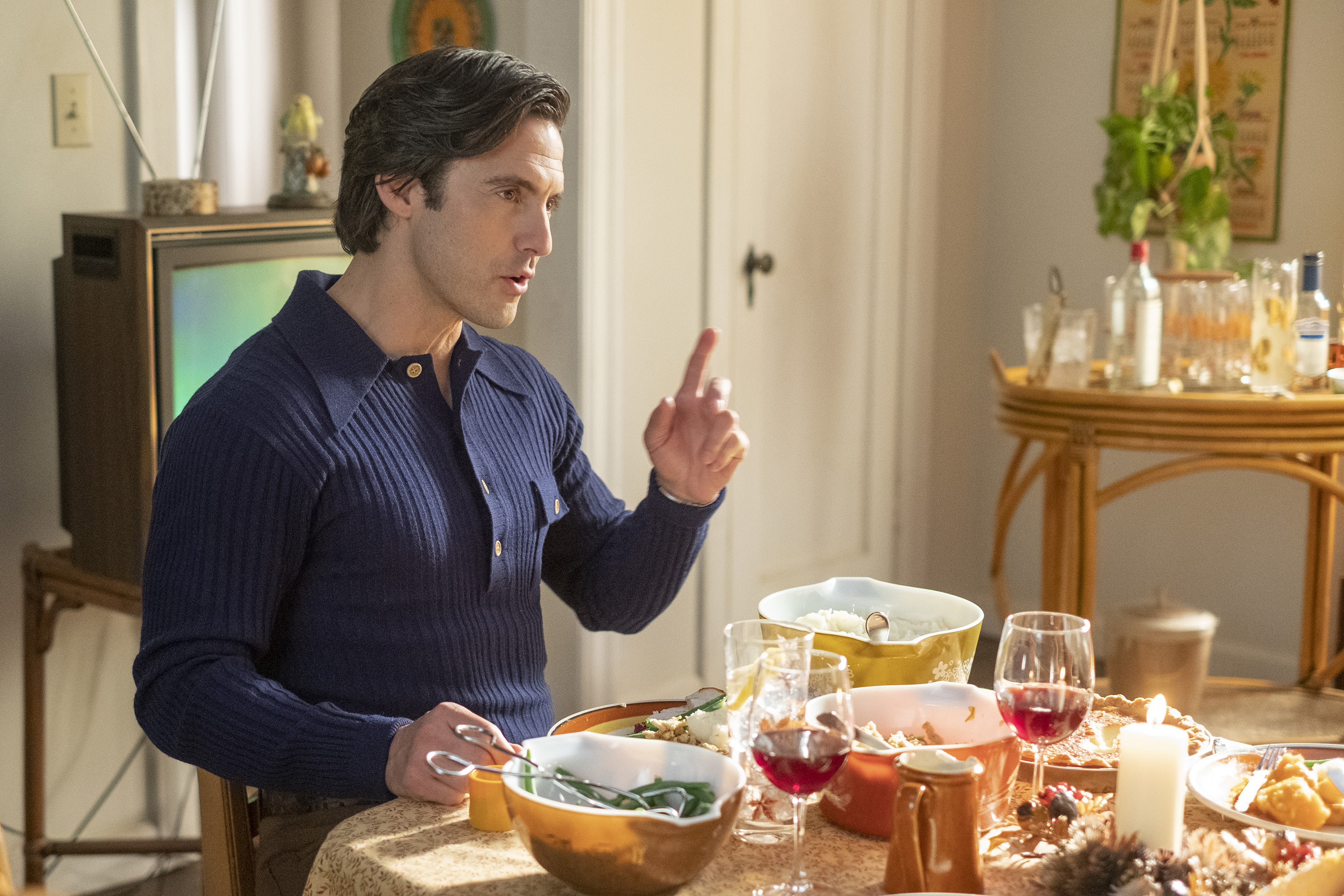 Milo Ventimiglia, in character as Jack Pearson in 'This Is Us' on NBC, wears a dark blue long-sleeved collared shirt and sits at the dinner table.